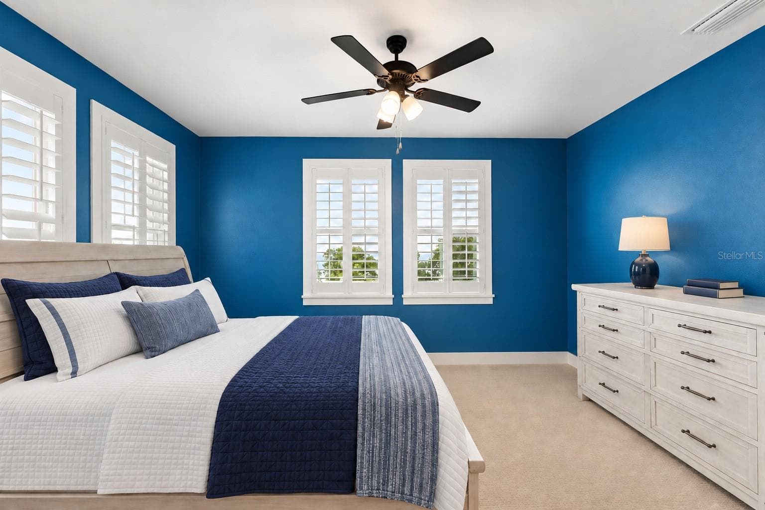 4TH BEDROOM/JACK&JILL. Lots of windows for great natural light. Back side of property. Virtual staging: items on floor removed, wall photos, accent rug, items on dresser. Lamp and bedding added - 907 CELADON ST, WINTER GARDEN