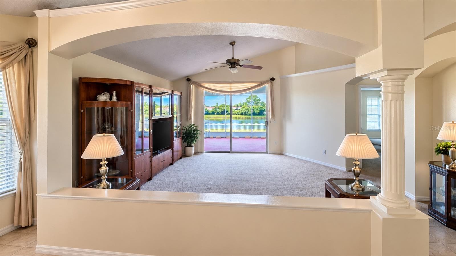 Formal Living with view of screened patio and pond - 7935 OAKSTONE CT, ORLANDO