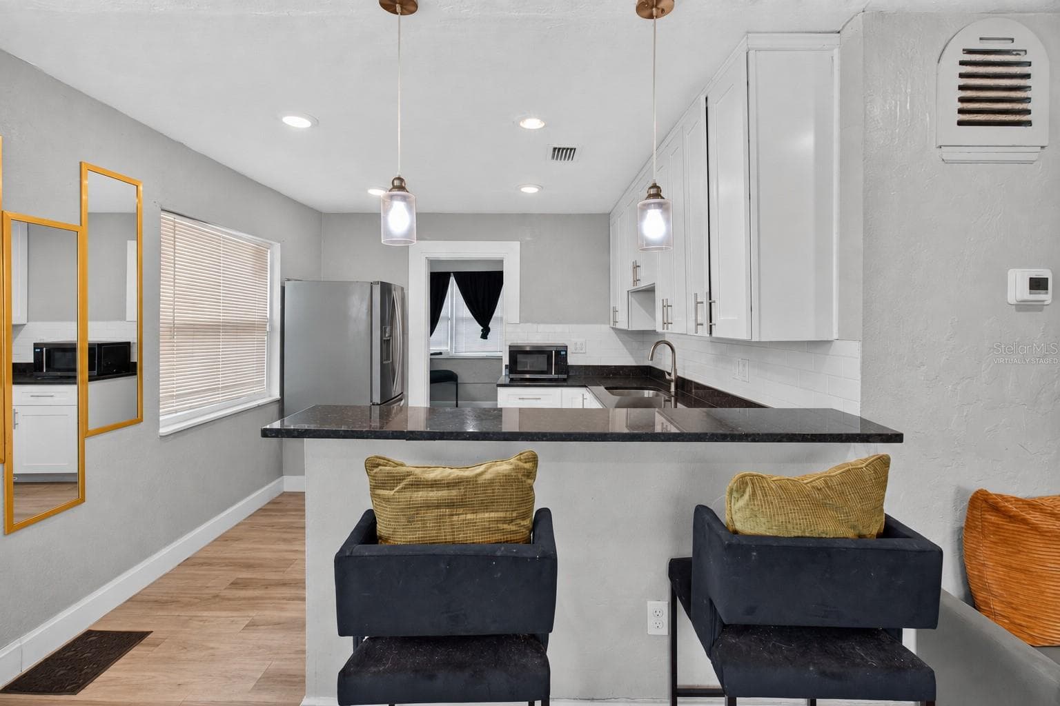 Virtually Staged. Personal Items digitally removed. Living room overlooking open kitchen with breakfast bar - 2452 17TH AVE S, ST PETERSBURG