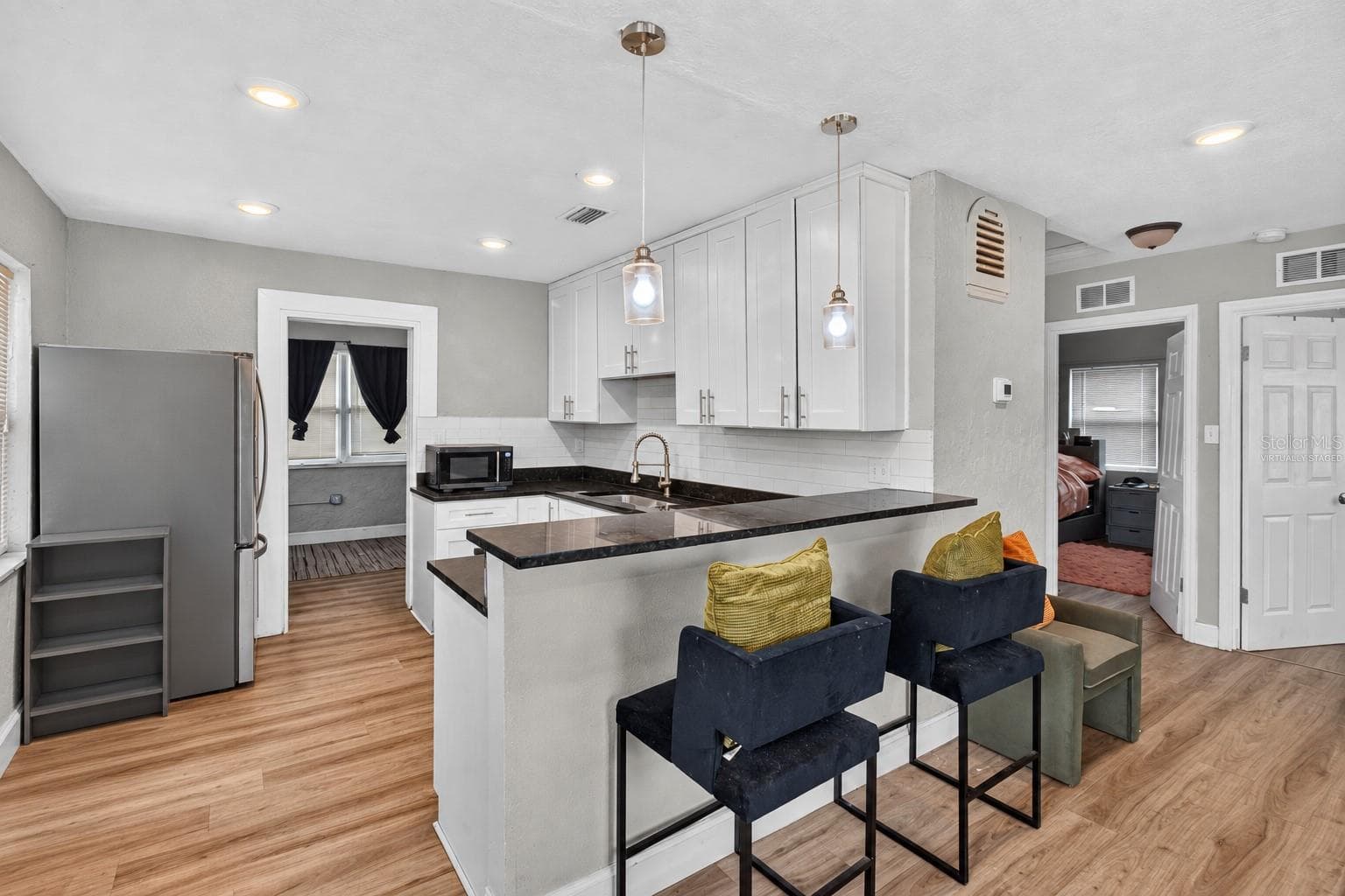 Virtually Staged. Personal Items digitally removed. Living room overlooking open kitchen with breakfast bar - 2452 17TH AVE S, ST PETERSBURG