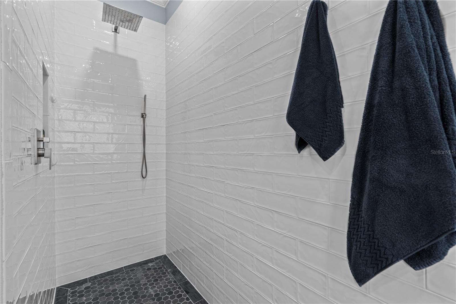 Walk-in/roll-in (no threshold) shower with rain shower head and spray wand; A storage niche is tucked away on the left - 520 SOTHEBY WAY, DEBARY