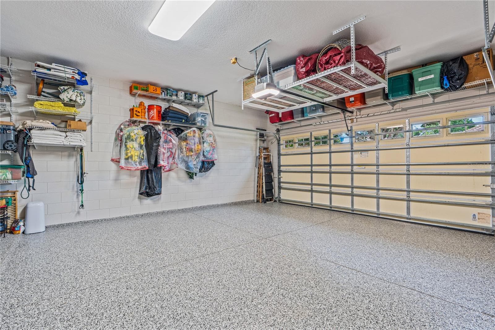 The shelving above the garage door and hanging in front of the garage door opener conveys; The shelving & hangers shown on the side wall does not convey - 520 SOTHEBY WAY, DEBARY
