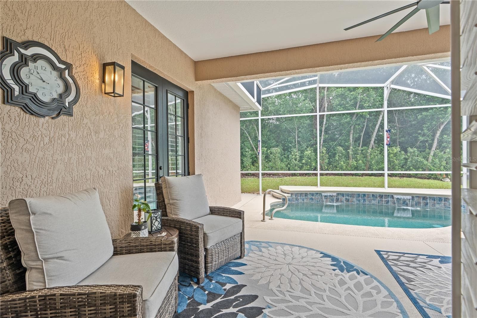 Looking out the French doors in the Great Room toward the refreshing pool -- the buffer of trees and shrubs offers privacy from the golf course just beyond - 520 SOTHEBY WAY, DEBARY
