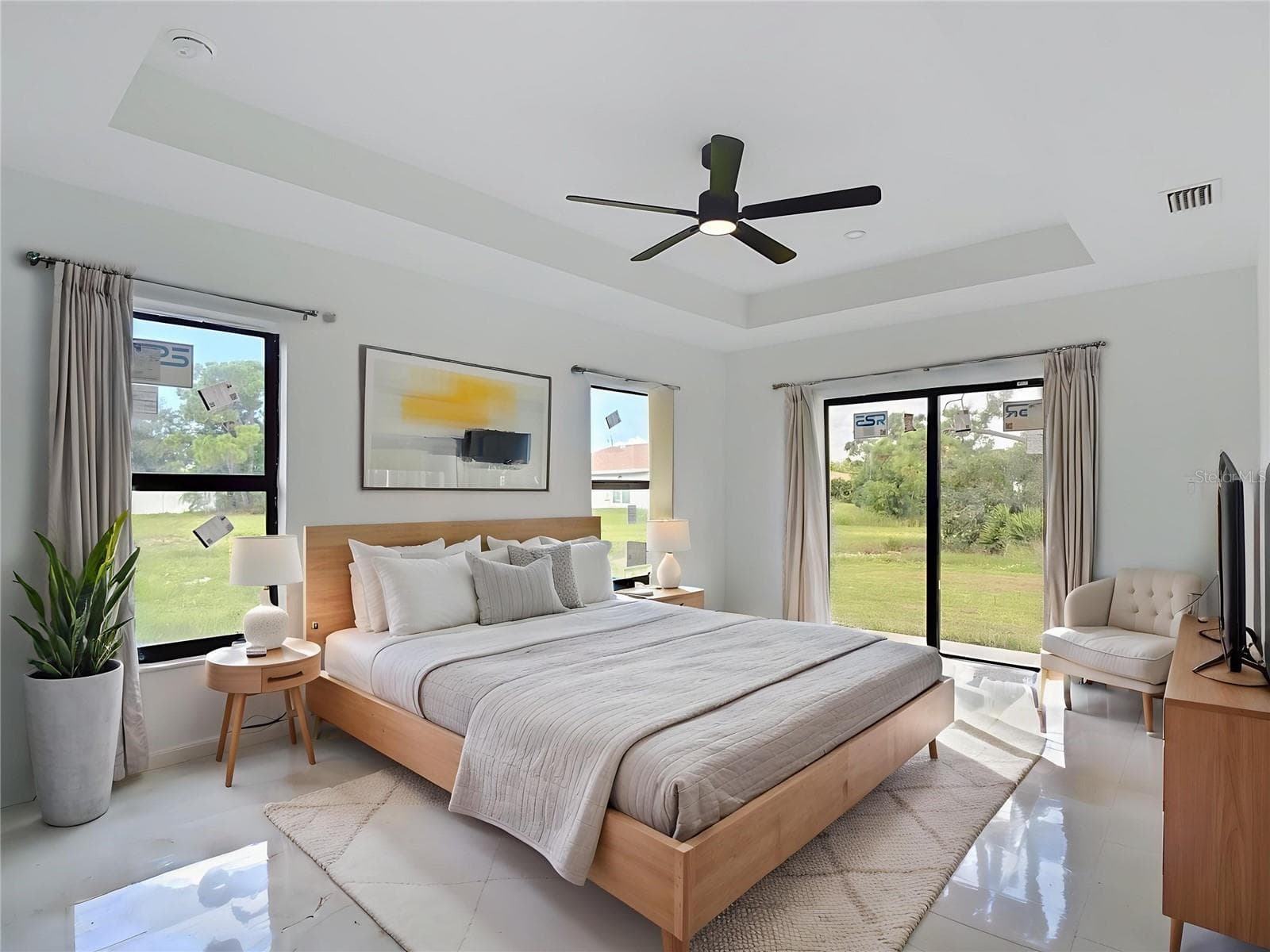 Staged primary bedroom with sliders onto the backyard. - 3613 NW 47TH LN, CAPE CORAL