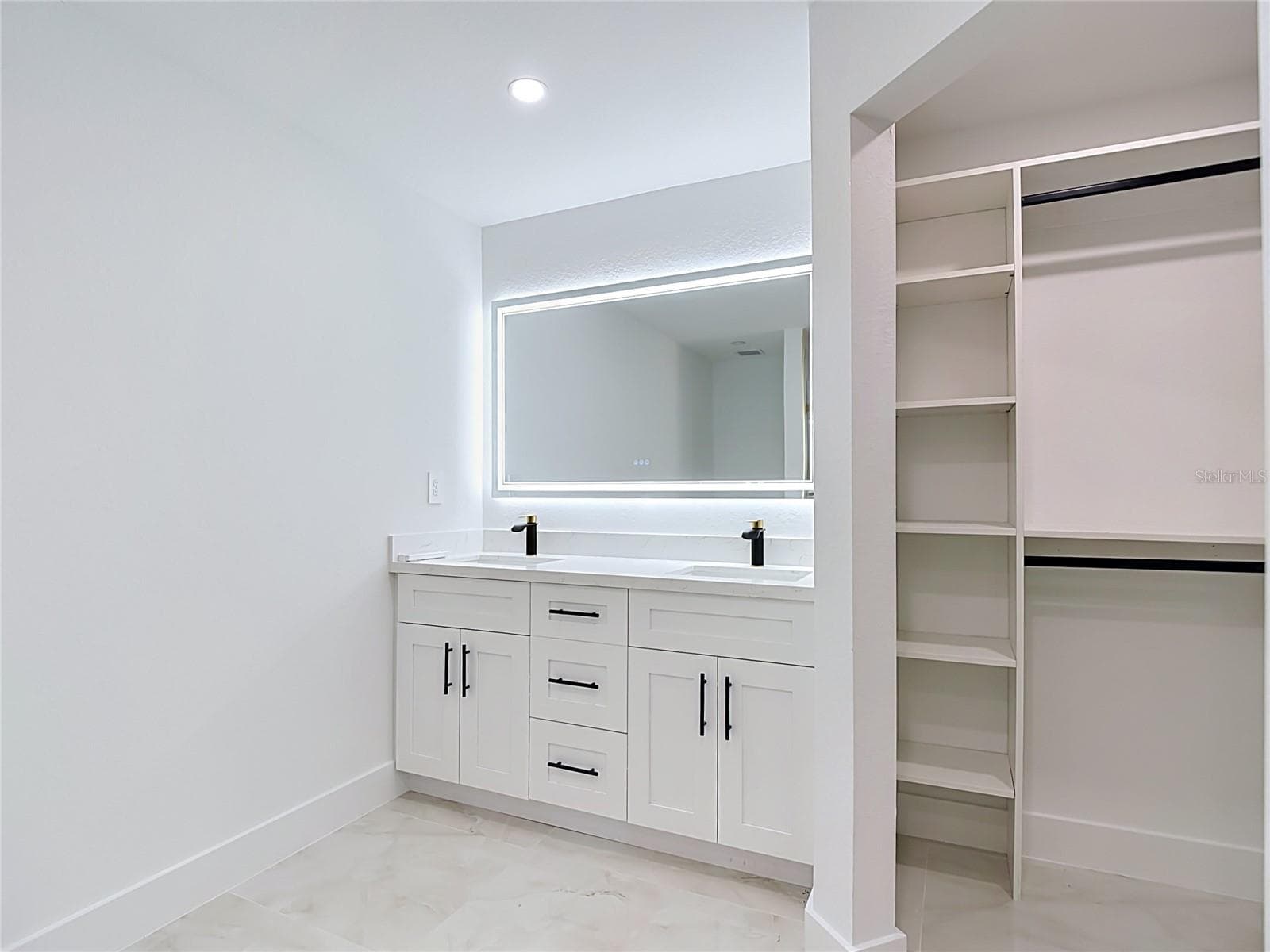 Bathroom with double vanity, smart lit mirror and closet with built in shelving - 3613 NW 47TH LN, CAPE CORAL