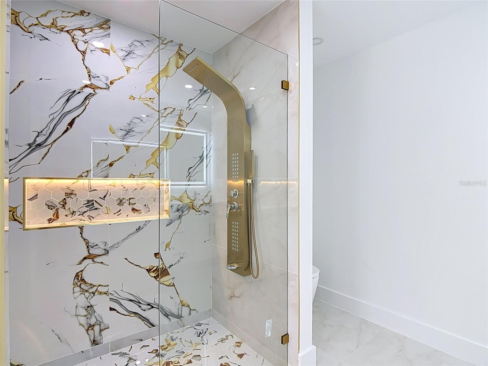 Elegant primary bathroom with tower shower and let cubby as well as the smart toilet - 3613 NW 47TH LN, CAPE CORAL