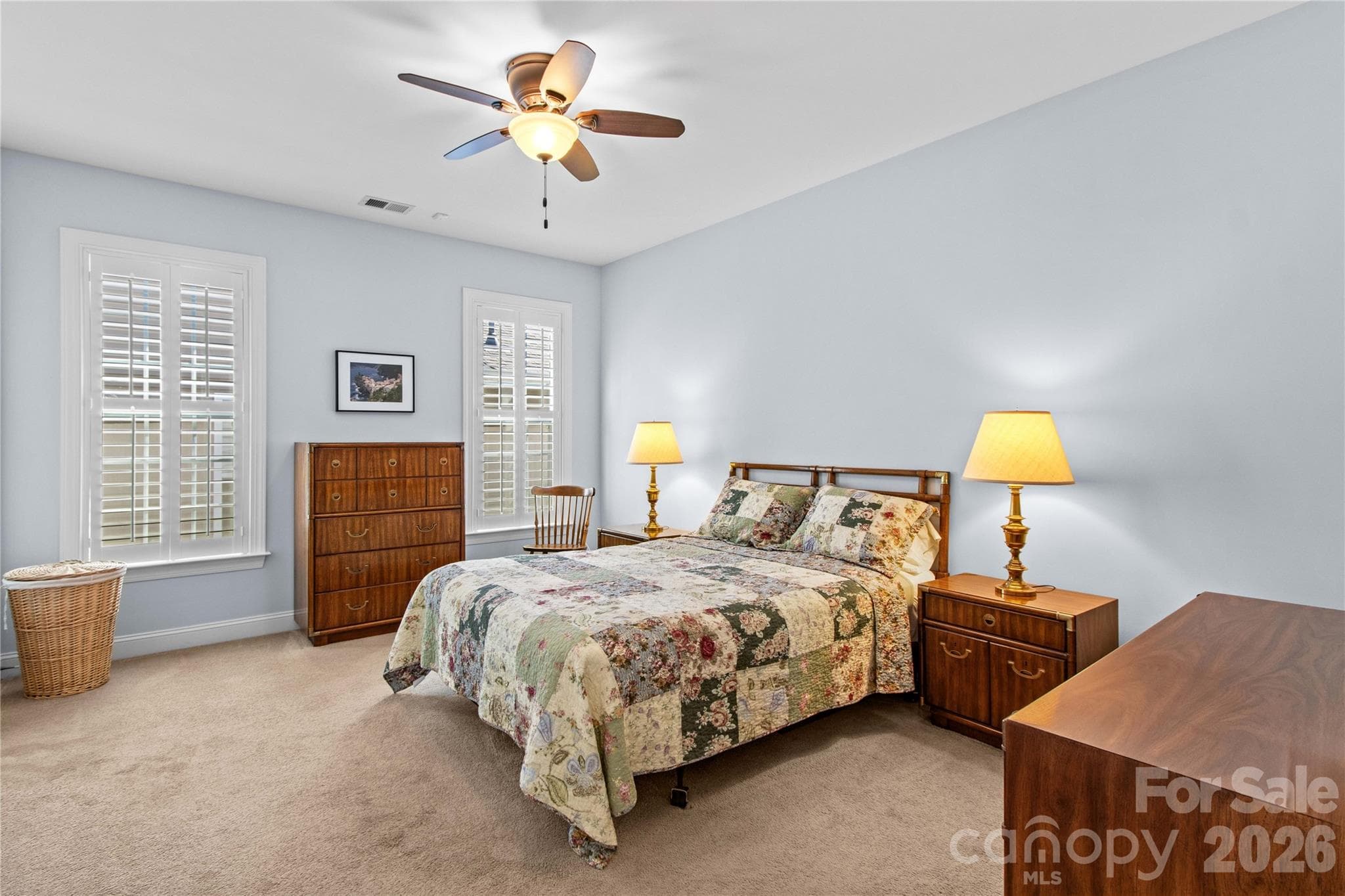 Spacious primary bedroom features a walk-in closet with custom shelving and an ensuite bathroom. - 18114 Ebenezer Drive, Cornelius