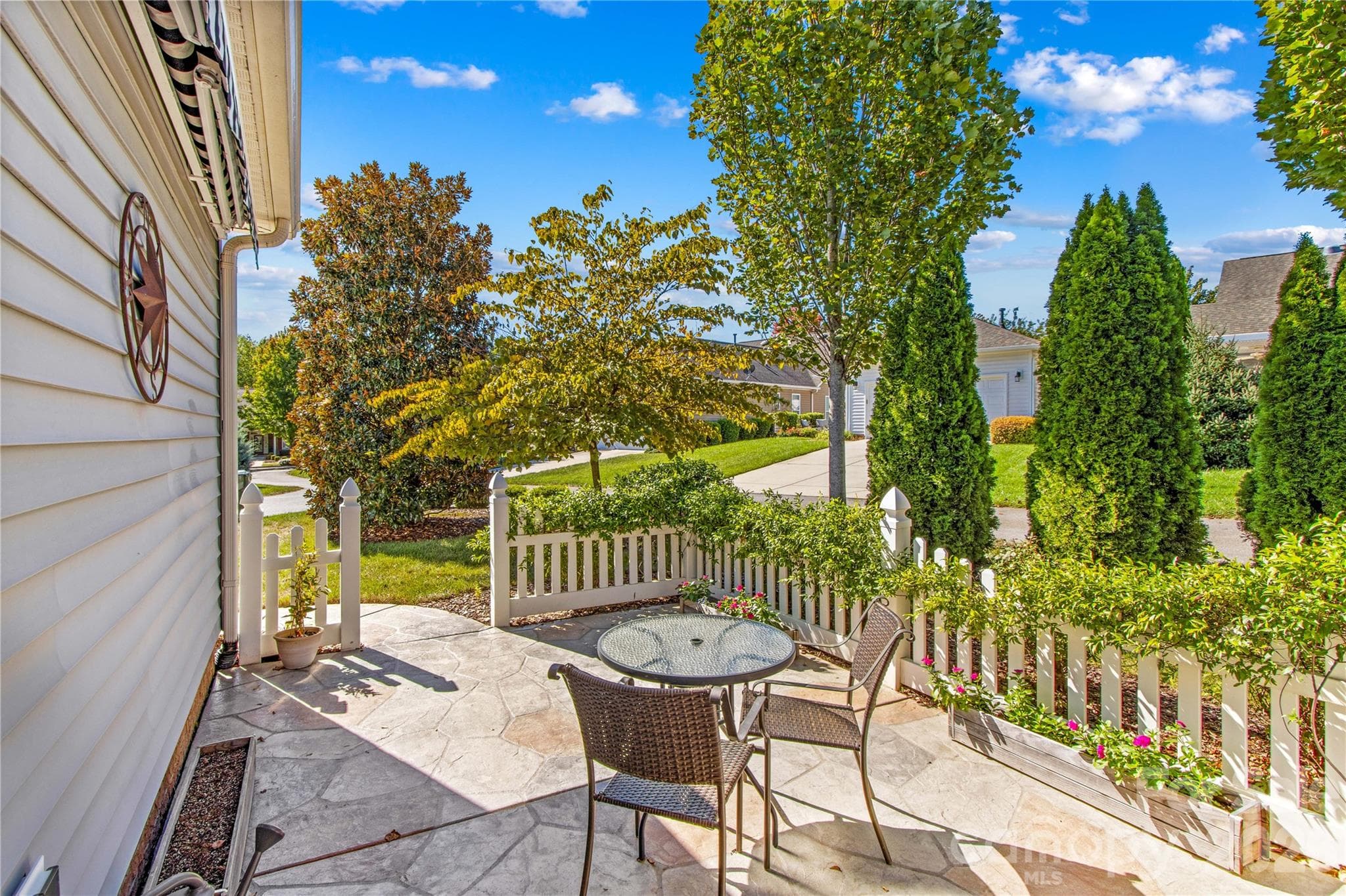 Stamped concrete patio is partially fenced with beautiful greenery and overlooks landscaped lot. - 18114 Ebenezer Drive, Cornelius