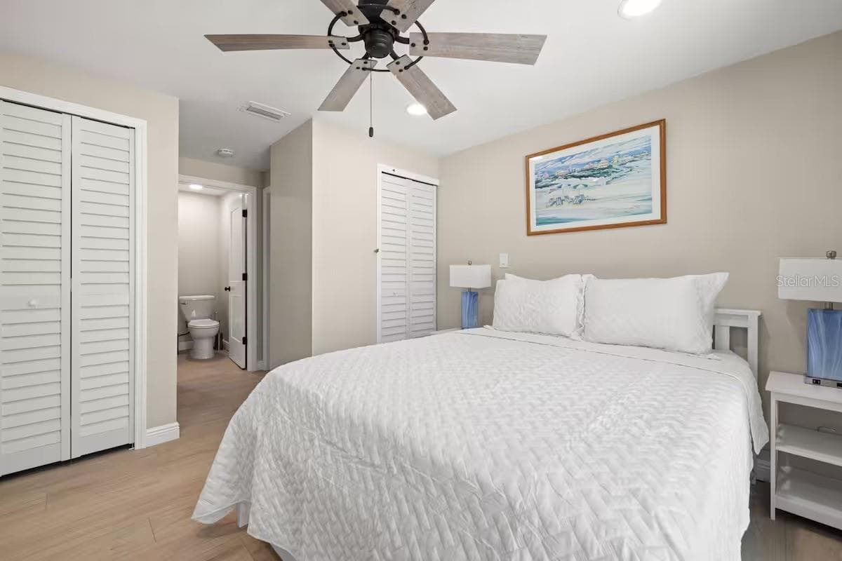 Another view of the primary suite highlights TWO CLOSETS and convenient access to the ensuite bath. - 201 SOUTH ST, PALM HARBOR