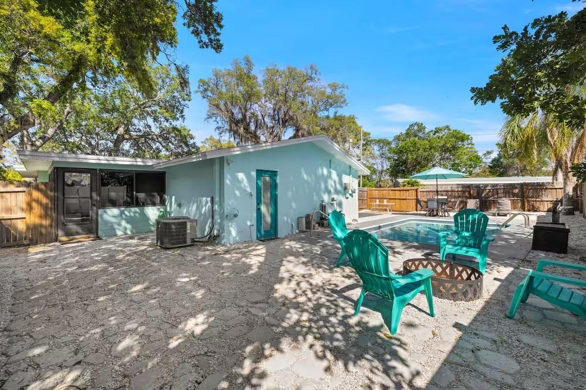 A fully fenced backyard offers more than just a pool, with a dedicated fire-pit area and plenty of space to gather outdoors. - 201 SOUTH ST, PALM HARBOR