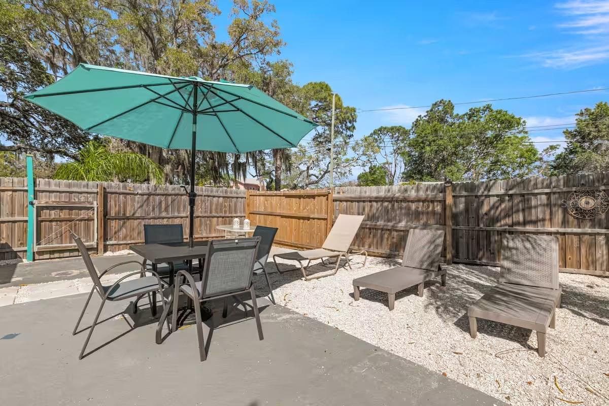 Multiple outdoor living areas provide space for dining in the shade, lounging poolside, or simply kicking back after a swim. - 201 SOUTH ST, PALM HARBOR