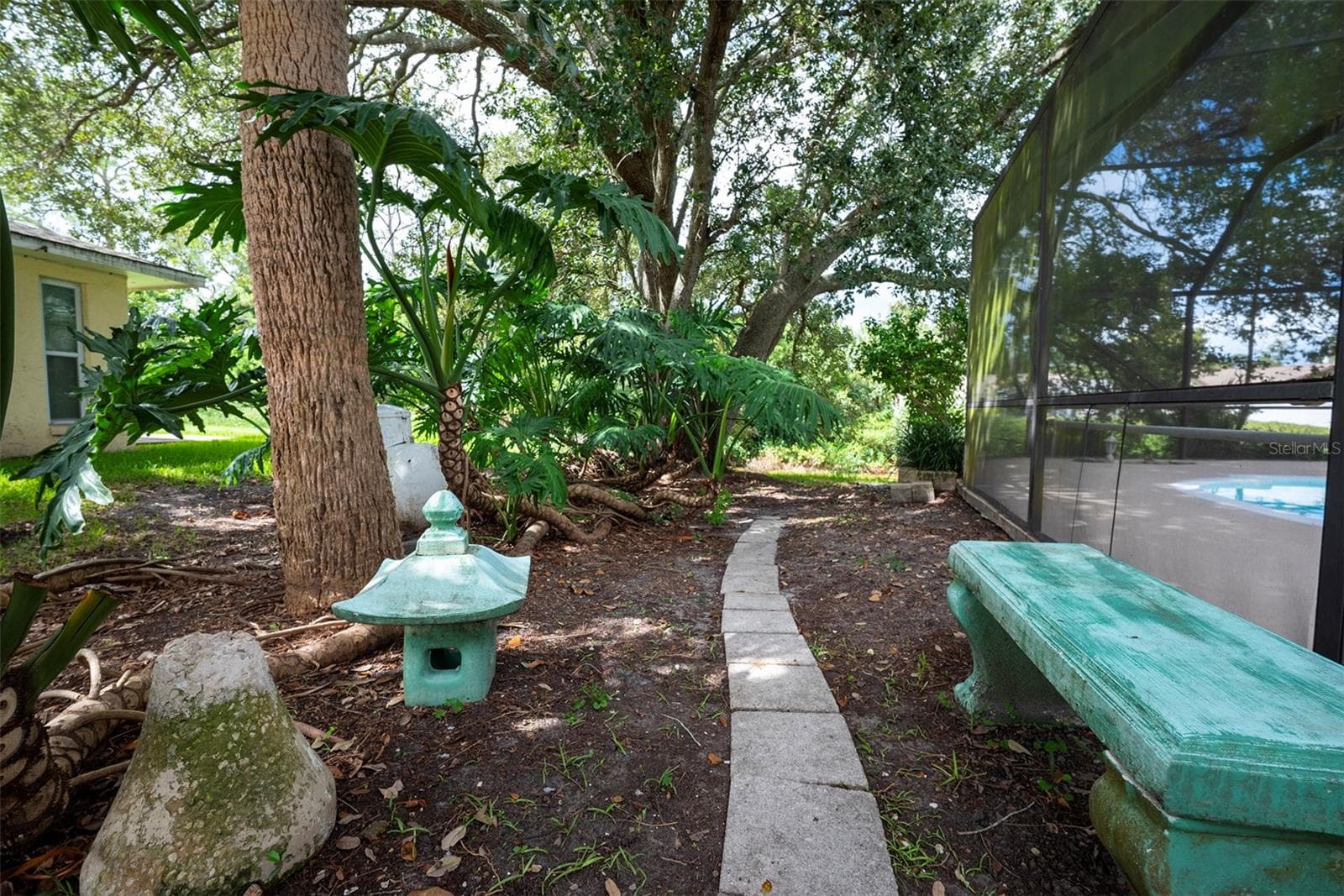 Small garden area with bench outside the lanai - 83 FARRAGUT DR, PALM COAST
