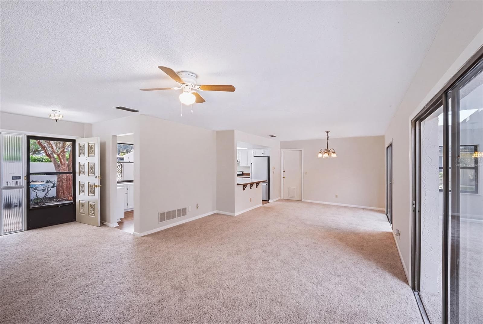 Virtually staged empty living room/dinette area - 83 FARRAGUT DR, PALM COAST