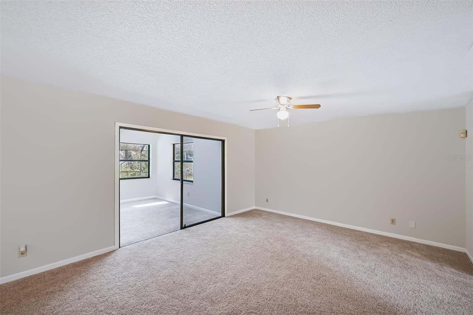 Living room with access to Florida room beyond the glass sliding doors - 83 FARRAGUT DR, PALM COAST