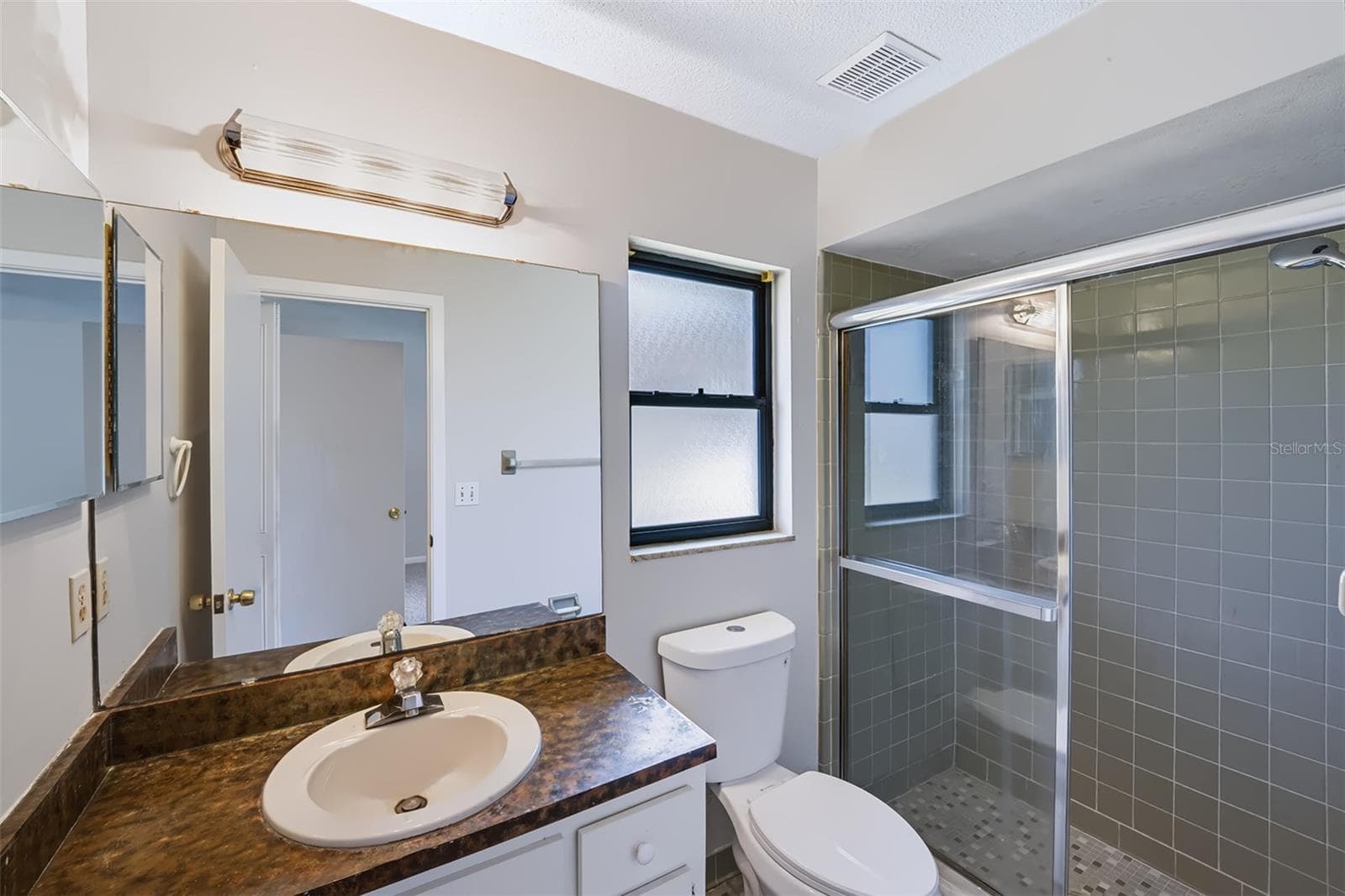 Master bathroom with shower, built-in medicine cabinet and retro-style glazed ceramic tile throughout - 83 FARRAGUT DR, PALM COAST