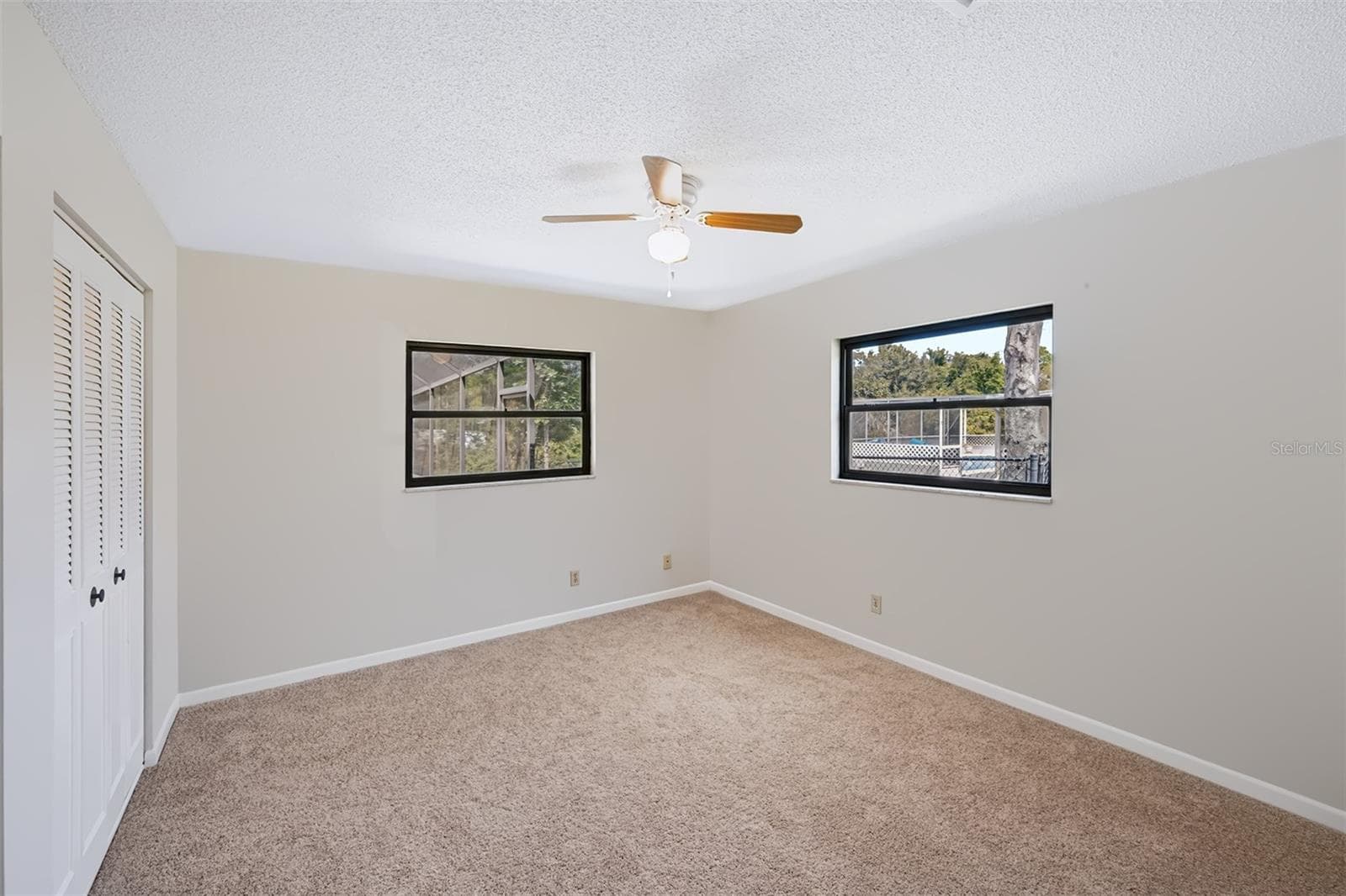 Secondary bedroom with double walk-in closets and view overlooking the pool/canal area - 83 FARRAGUT DR, PALM COAST