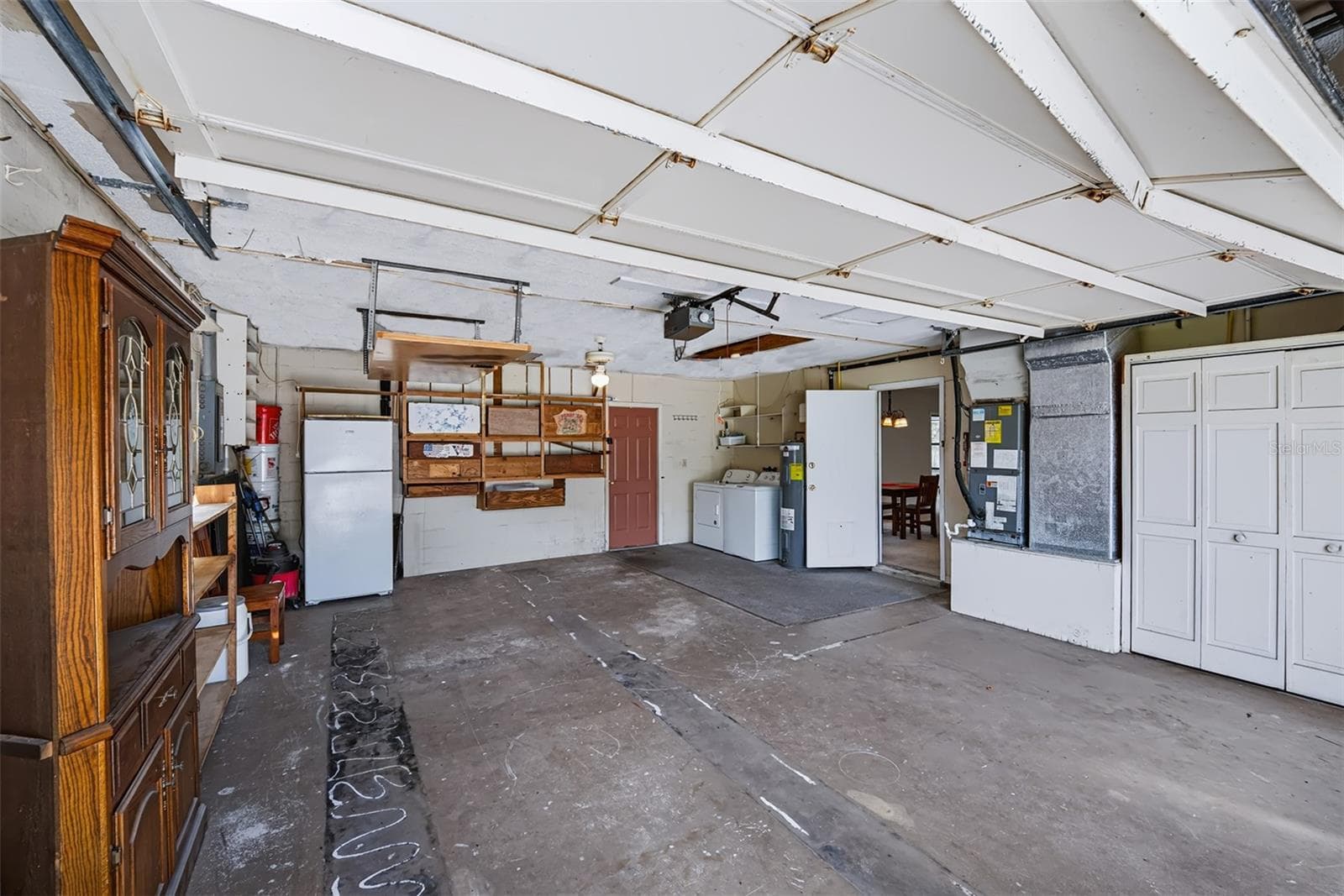 This 2-car garage exhibits plenty of storage space. This area also houses the HVAC, hot water heater and washer/dryer hook-up. Door to the right is an entry into the house, door at the back takes you out to the pool/lanai area - 83 FARRAGUT DR, PALM COAST