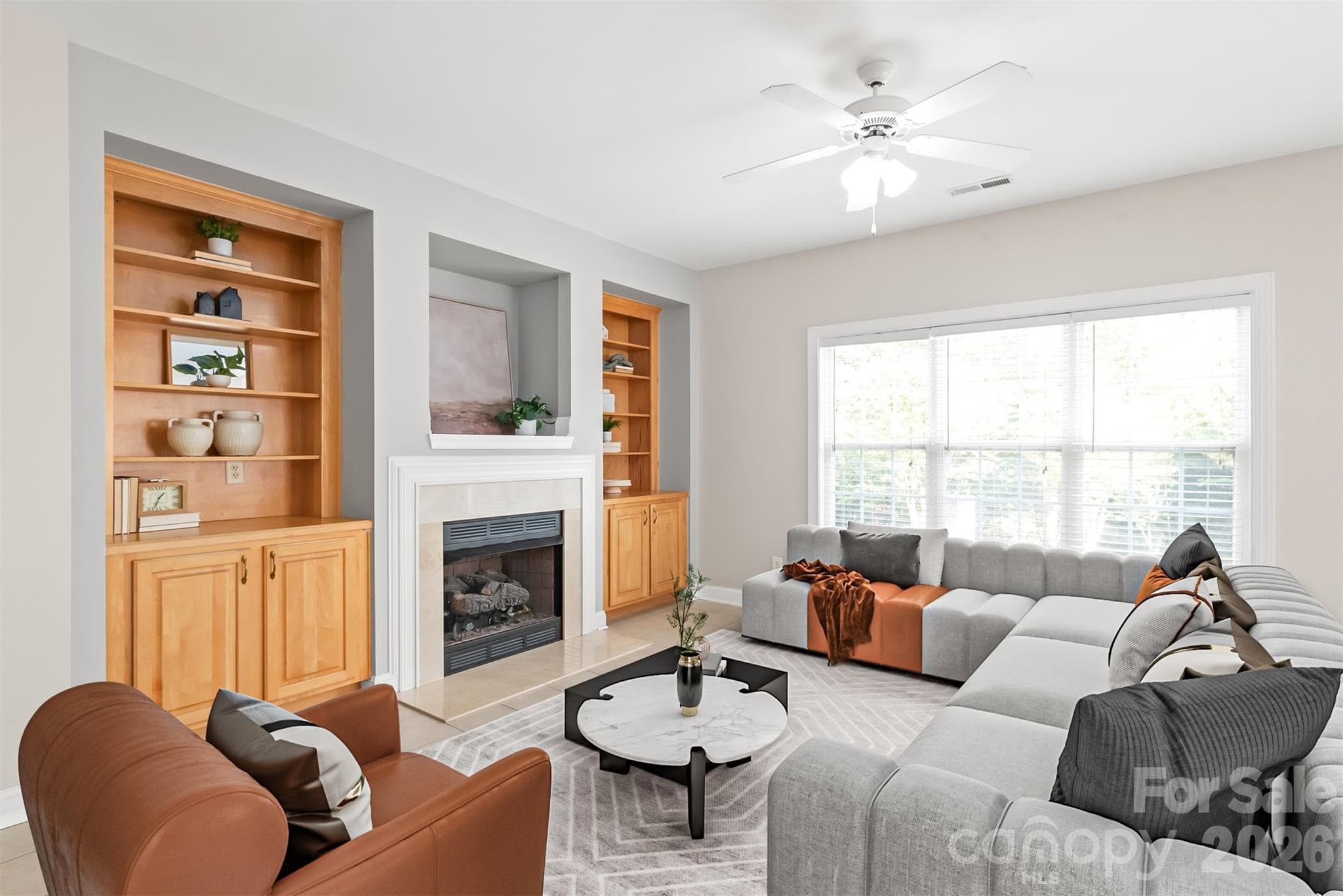 The cozy open living room serves as the heart of the home, featuring a warm gas fireplace framed by built-in bookshelves and cabinets for storage. Virtually Staged. - 2008 Trace Creek Drive, Waxhaw