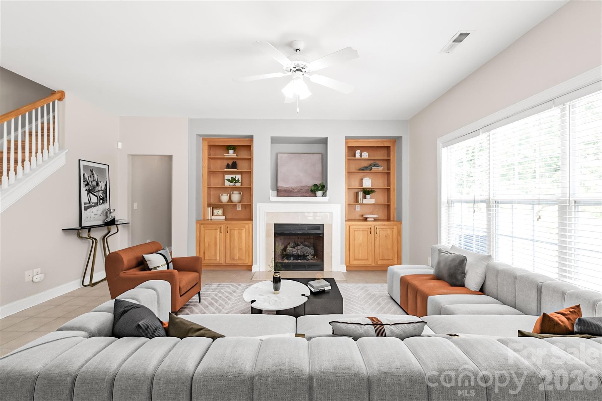 Built-in shelving and cabinet storage frame the living room, blending classic architectural detail with convenient space to display decor and tuck everyday items out of view. Virtually Staged. - 2008 Trace Creek Drive, Waxhaw
