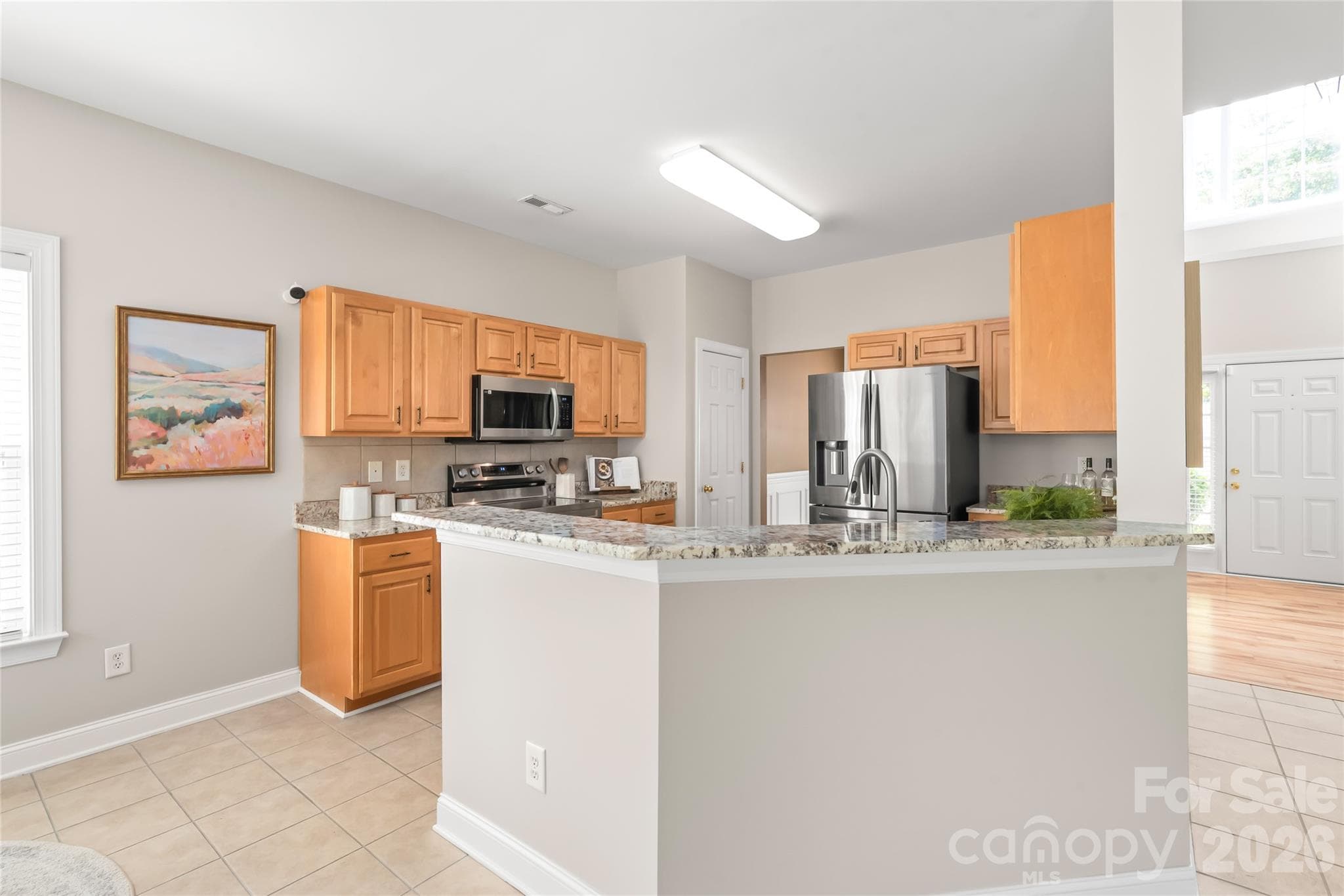 This chef-inspired kitchen shines with updated granite countertops, tile backsplash, sleek stainless steel appliances, and plenty of prep space for cooking. - 2008 Trace Creek Drive, Waxhaw