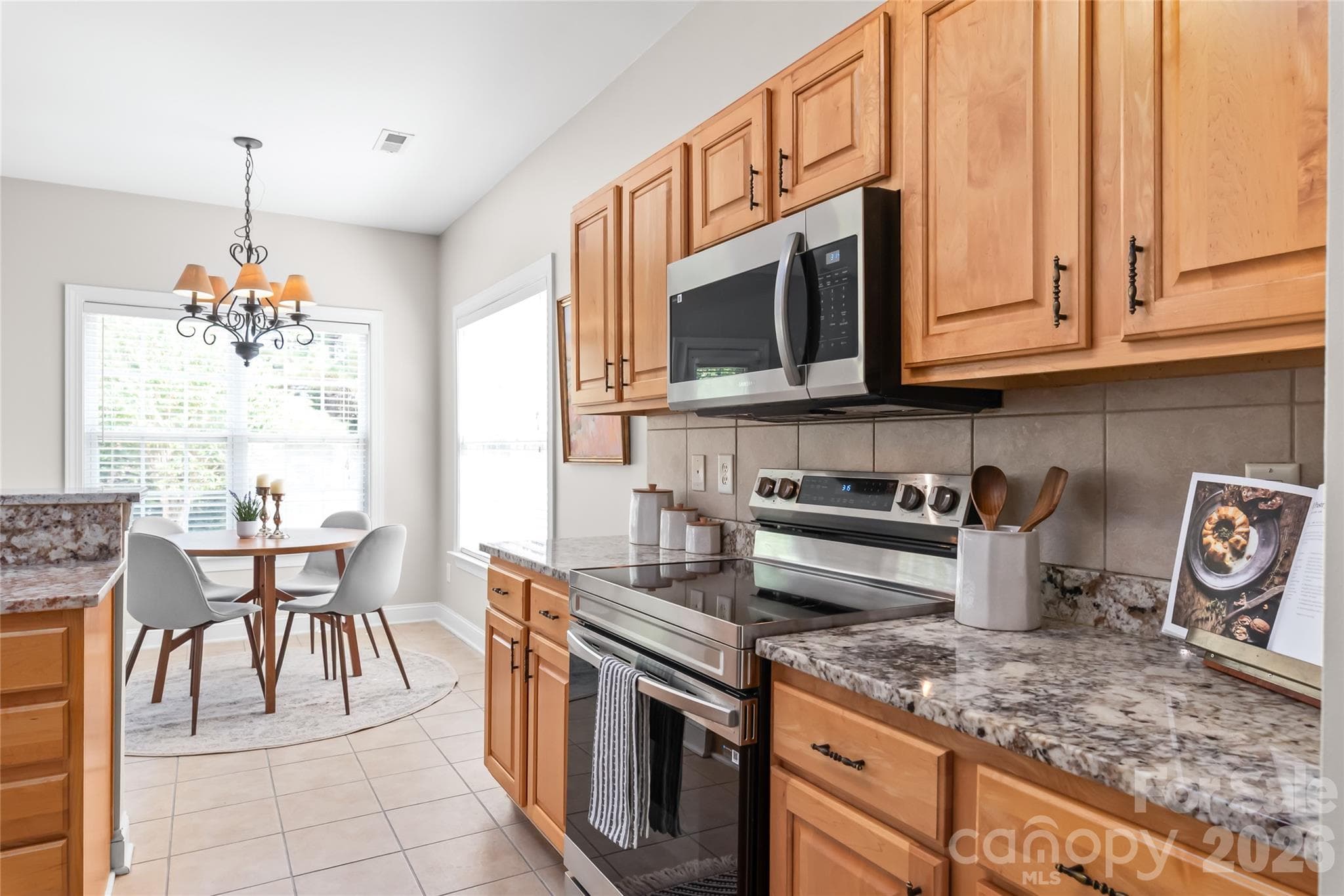 Fully equipped for everyday meals and weekend entertaining, the kitchen features an electric range and oven paired with a convenient built-in microwave for seamless prep and cooking. - 2008 Trace Creek Drive, Waxhaw