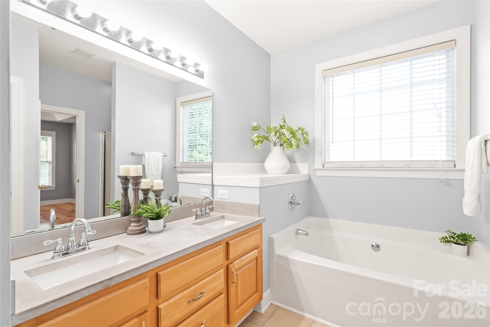 The primary ensuite boasts updated countertops, sleek double sinks with ample prep space, and garden tub. - 2008 Trace Creek Drive, Waxhaw