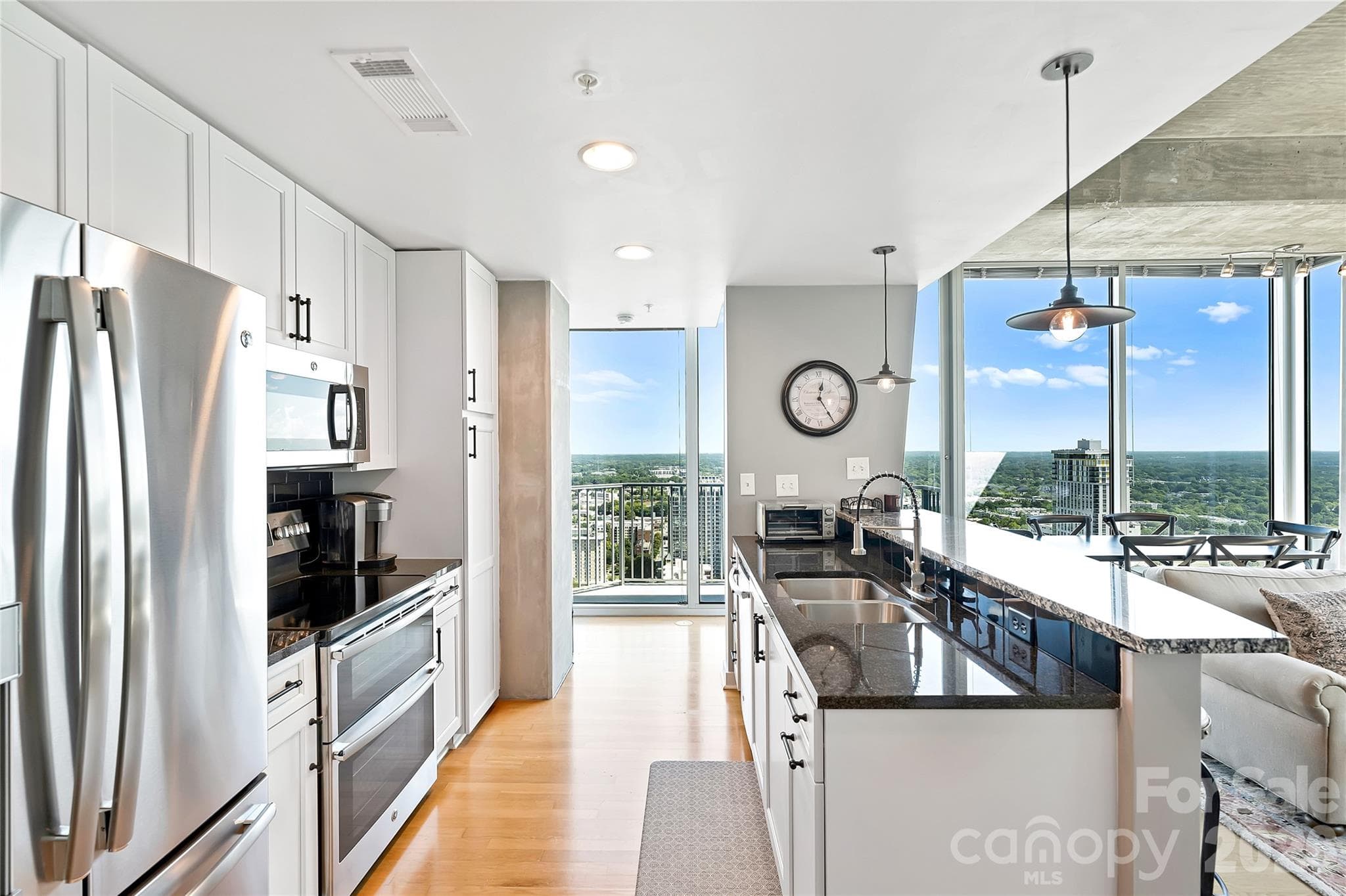Open kitchen with island seating and walls of glass beyond - 210 N Church Street, Charlotte