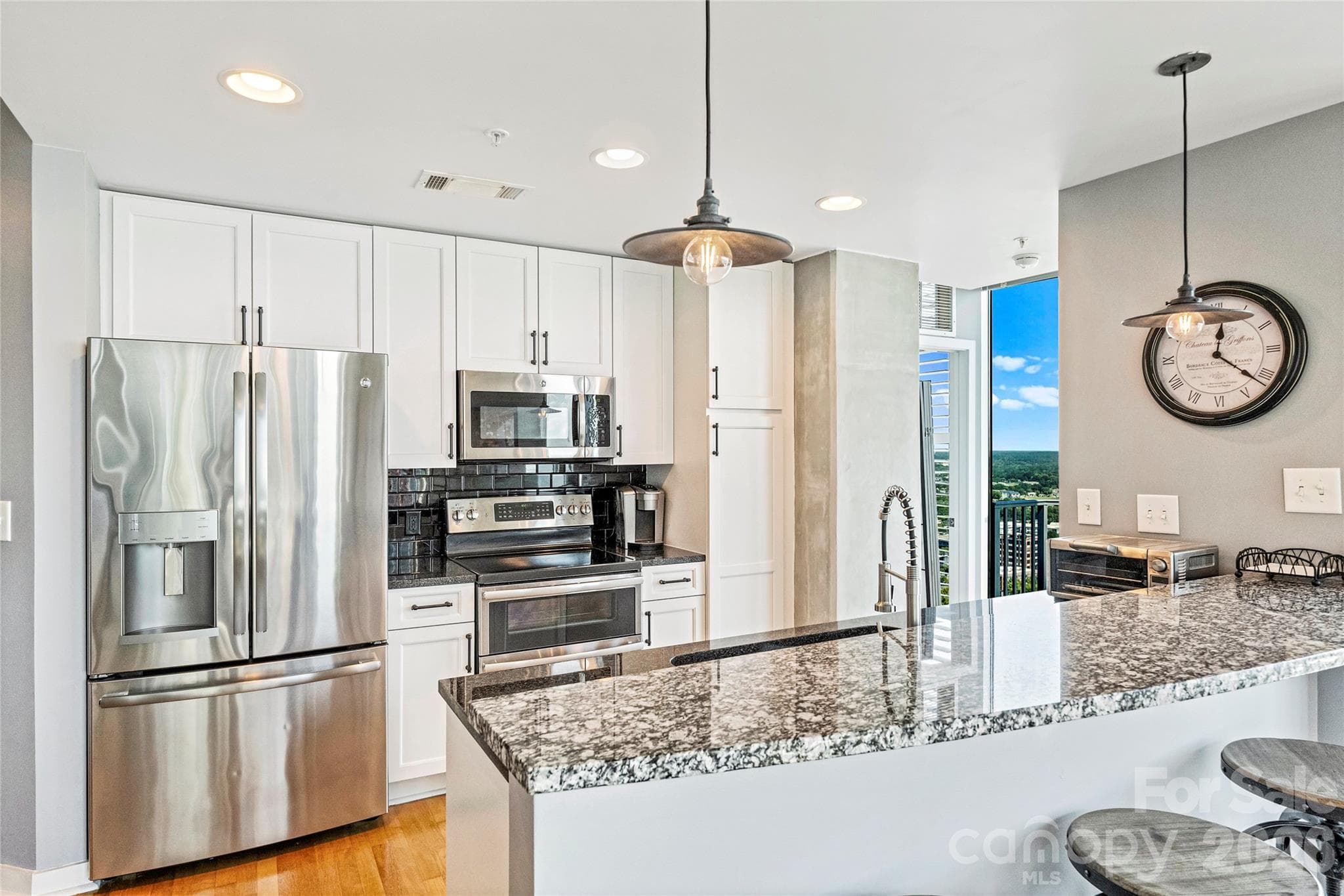 Updated kitchen with white cabinetry and island seating - 210 N Church Street, Charlotte