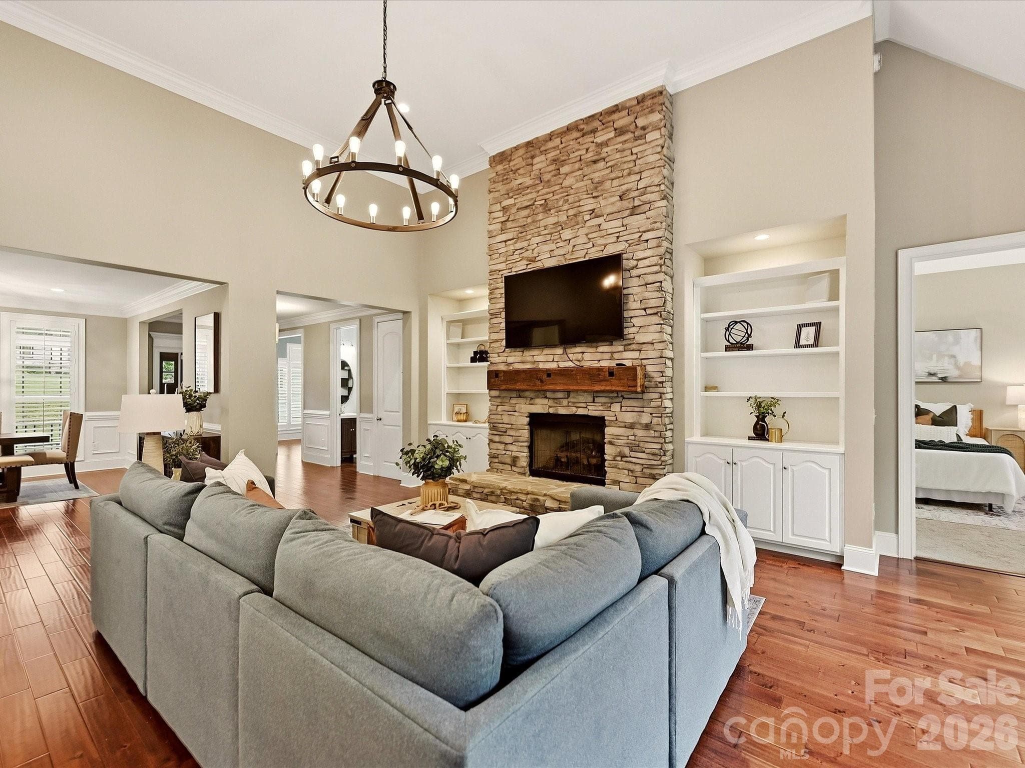 Great Room showcases soaring ceilings, rich floors, a dramatic floor-to-ceiling stacked-stone fireplace with custom built-ins, and an open layout ideal for everyday living and entertaining. - 3167 James Plantation Drive, Denver