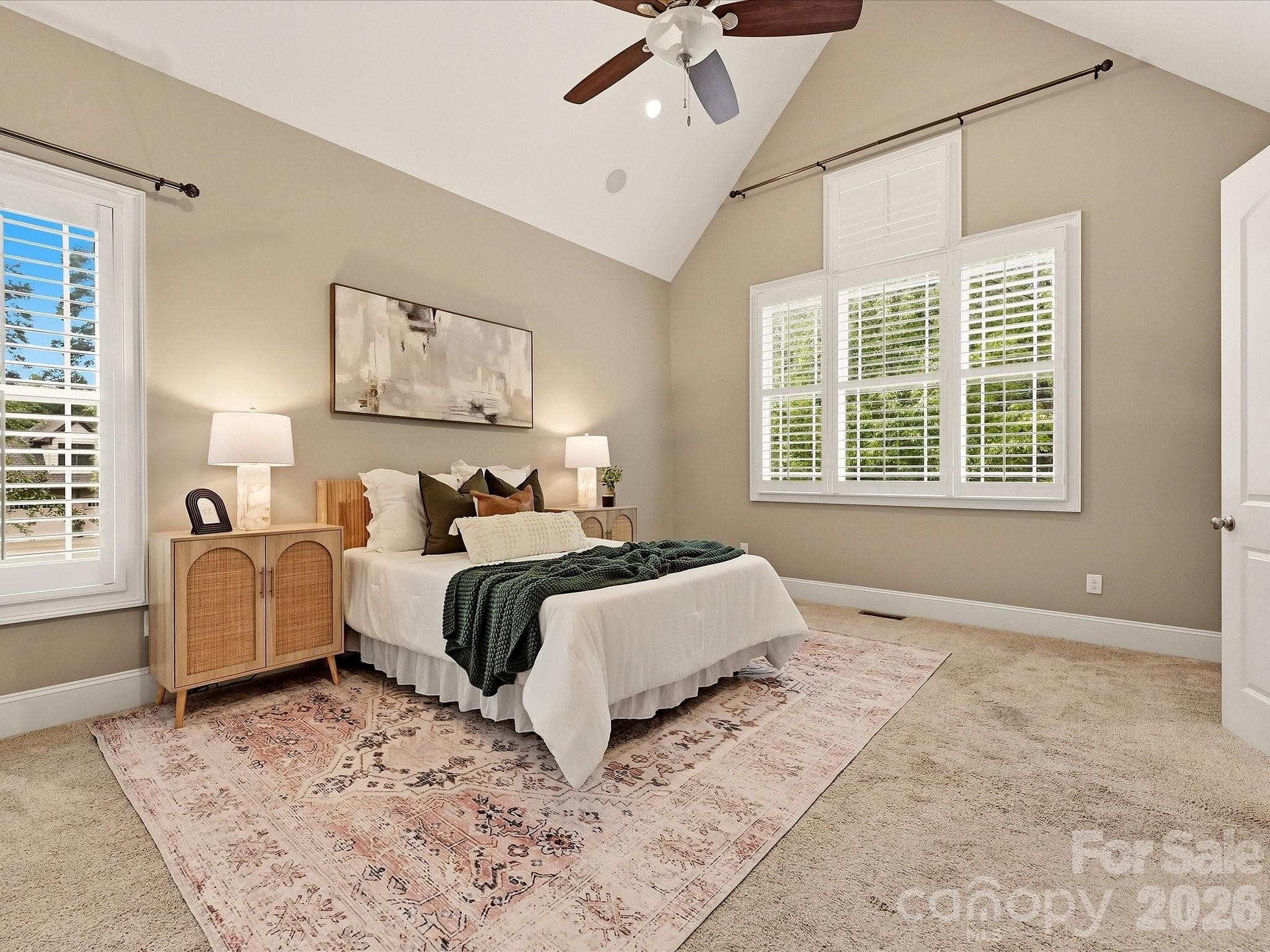 A spacious Primary Suite offers vaulted ceilings, abundant natural light, plantation shutters, plush carpeting, and direct access to the ensuite bath and walk-in closet. - 3167 James Plantation Drive, Denver
