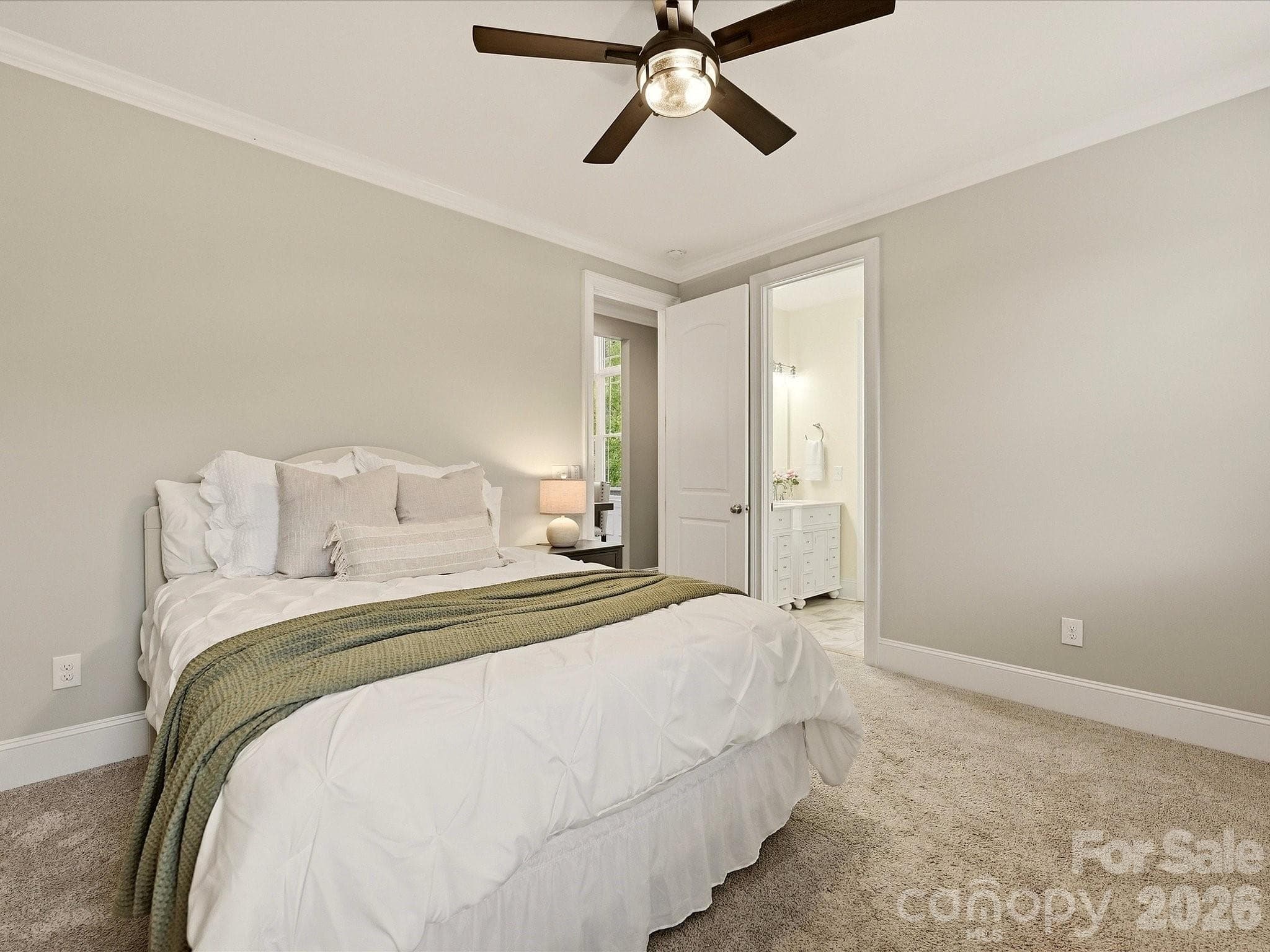 Bedroom 2 offers generous space, soft carpeting, crown molding, abundant natural light, a ceiling fan, and convenient access to a full bath. - 3167 James Plantation Drive, Denver
