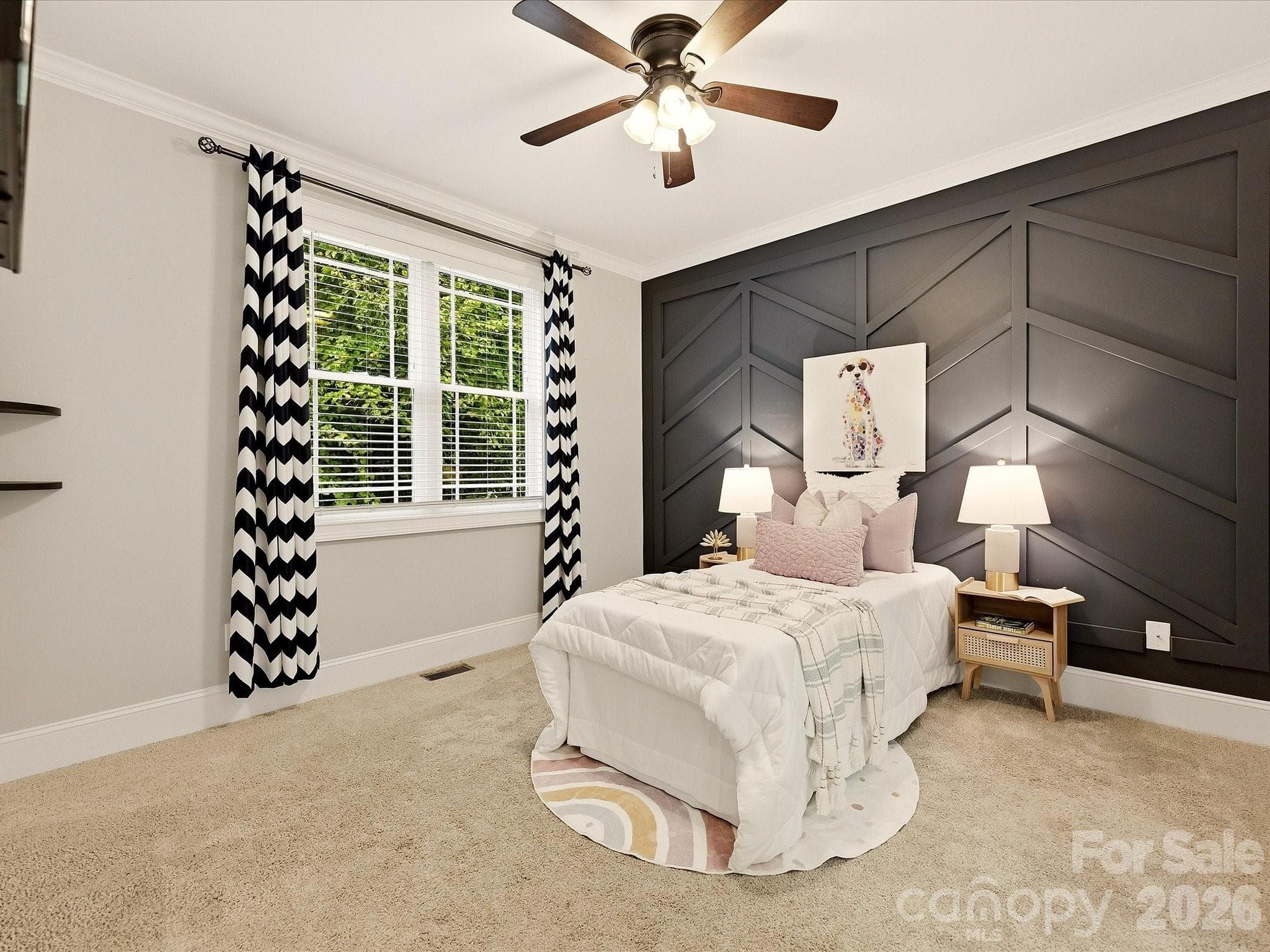 Bedroom 3 offers generous space, soft carpeting, a ceiling fan, abundant natural light, and a striking geometric accent wall for added character. - 3167 James Plantation Drive, Denver