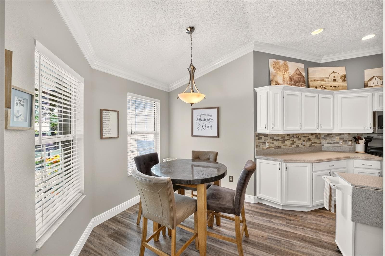 Breakfast Area: Casual dining nook offers windows on two sides for natural light, a pendant fixture, and convenient placement directly beside the kitchen. - 2749 BANYAN PL, THE VILLAGES