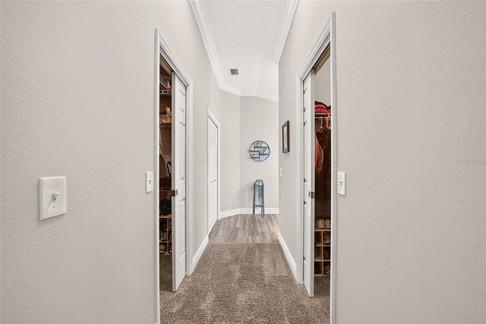 Closet Hall: Dedicated dressing and storage area provides access to two closets, offering convenient organization adjacent to the bedroom suite. - 2749 BANYAN PL, THE VILLAGES