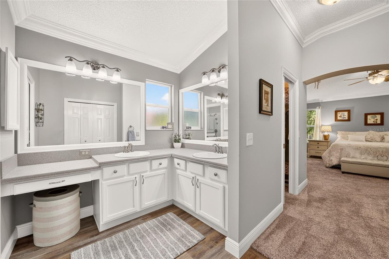 Primary Bathroom: Dual-sink vanity provides extensive counter and cabinet storage, complemented by large mirrors and a separate dressing area. - 2749 BANYAN PL, THE VILLAGES