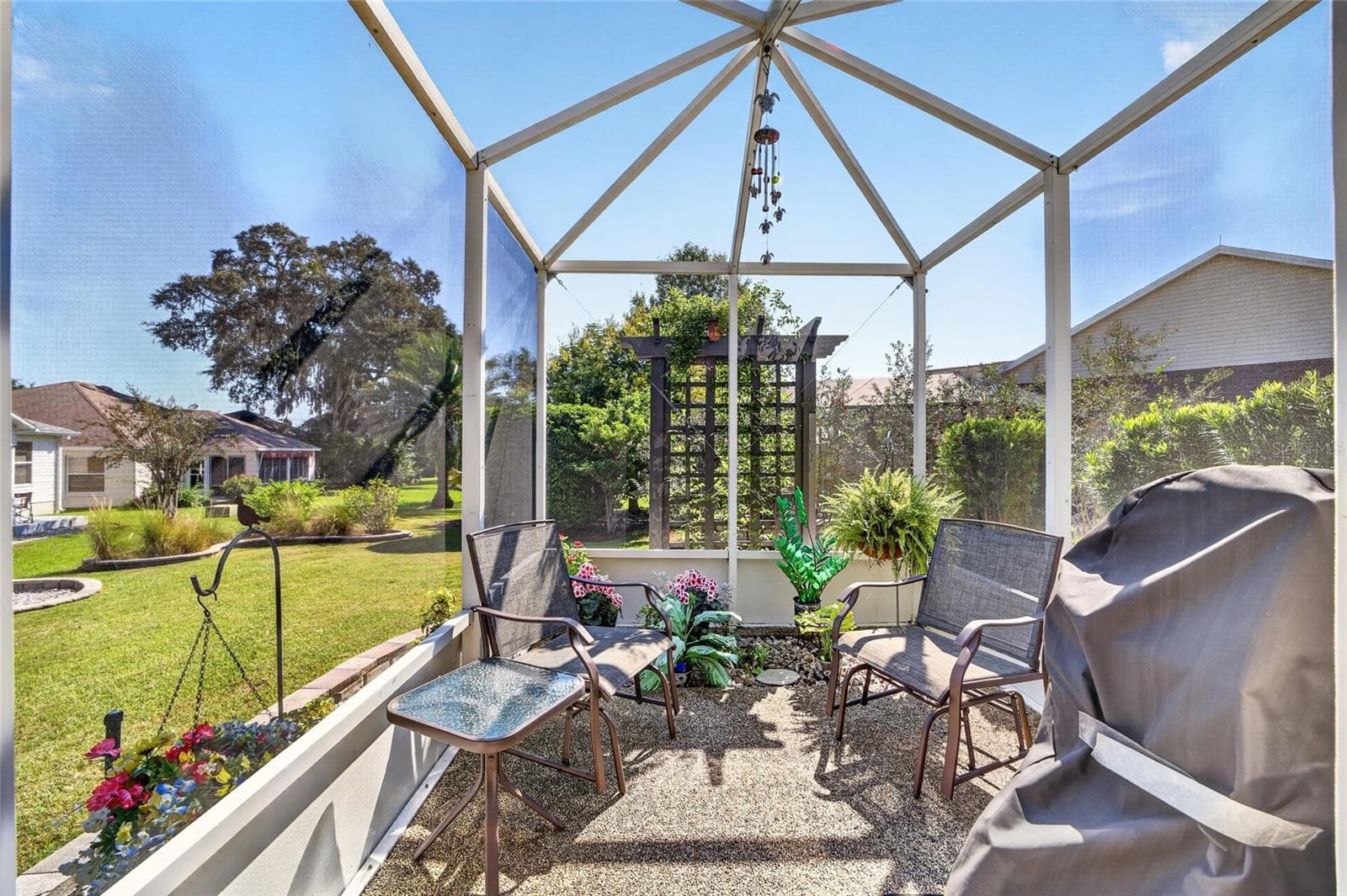 Screened Patio: Outdoor screened patio creates an additional space for seating and grilling while overlooking the surrounding landscaping. - 2749 BANYAN PL, THE VILLAGES