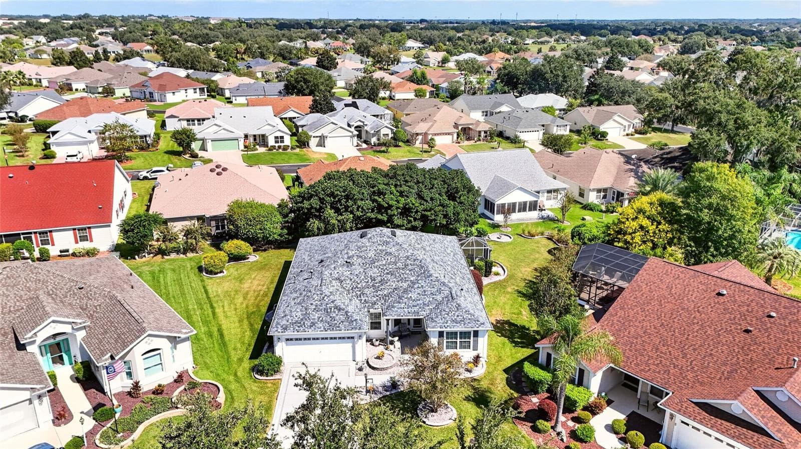 Aerial View: Elevated perspective showcases the home, surrounding lawn and landscaping, and its setting within the neighborhood. - 2749 BANYAN PL, THE VILLAGES