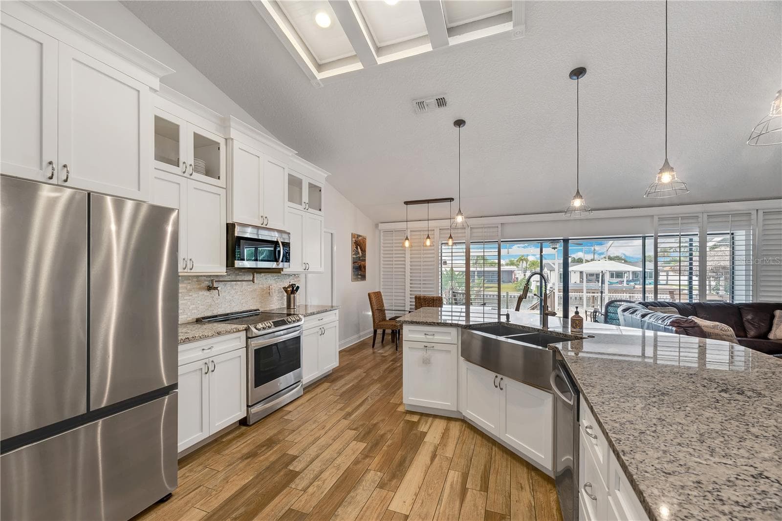 Kitchen features custom cabinetry, granite countertops, stainless steel appliances, and a spacious breakfast bar. - 743 KINGSTON CT, APOLLO BEACH