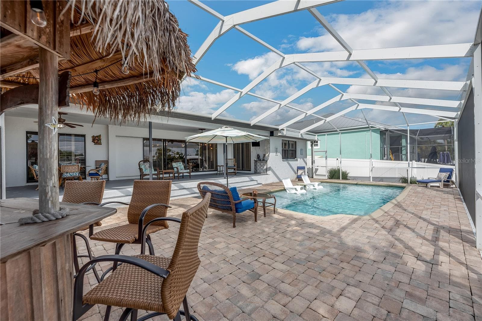 screened outdoor retreat featuring a heated saltwater pool, Tiki bar and spacious pavered deck. - 743 KINGSTON CT, APOLLO BEACH