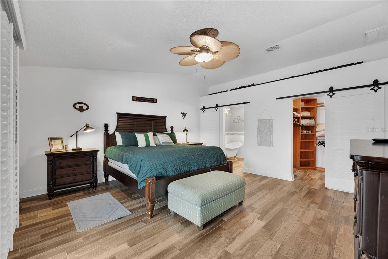 The cathedral ceiling and dual sliding barn doors give a charming vibe. - 743 KINGSTON CT, APOLLO BEACH