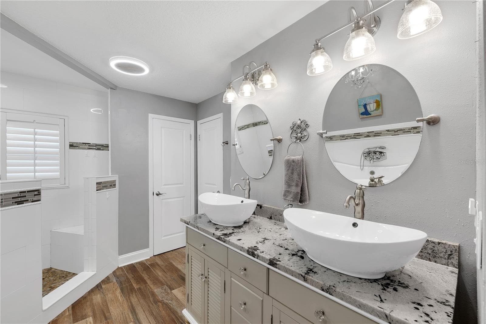 The primary bathroom has a large corner shower with multiple showerheads and built-in bench, dual sinks, linen closet storage and private water closet. - 743 KINGSTON CT, APOLLO BEACH