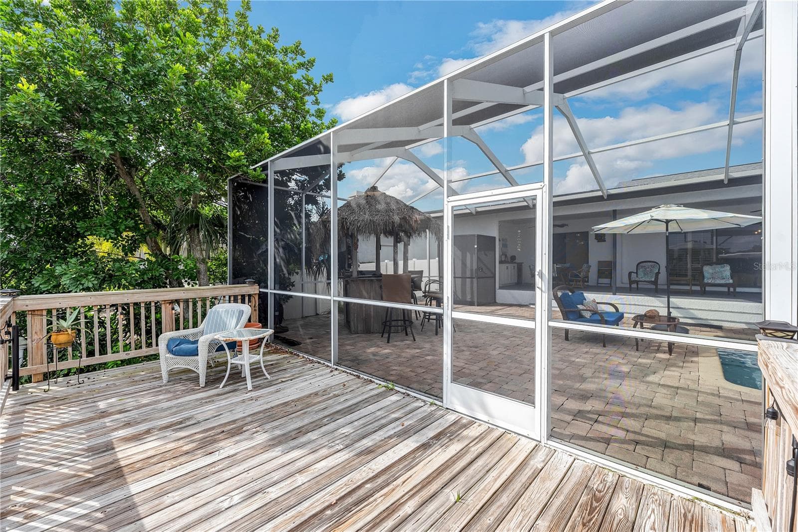 A spacious, open-air wooden deck just beyond the pool cage extends the outdoor entertaining area. - 743 KINGSTON CT, APOLLO BEACH