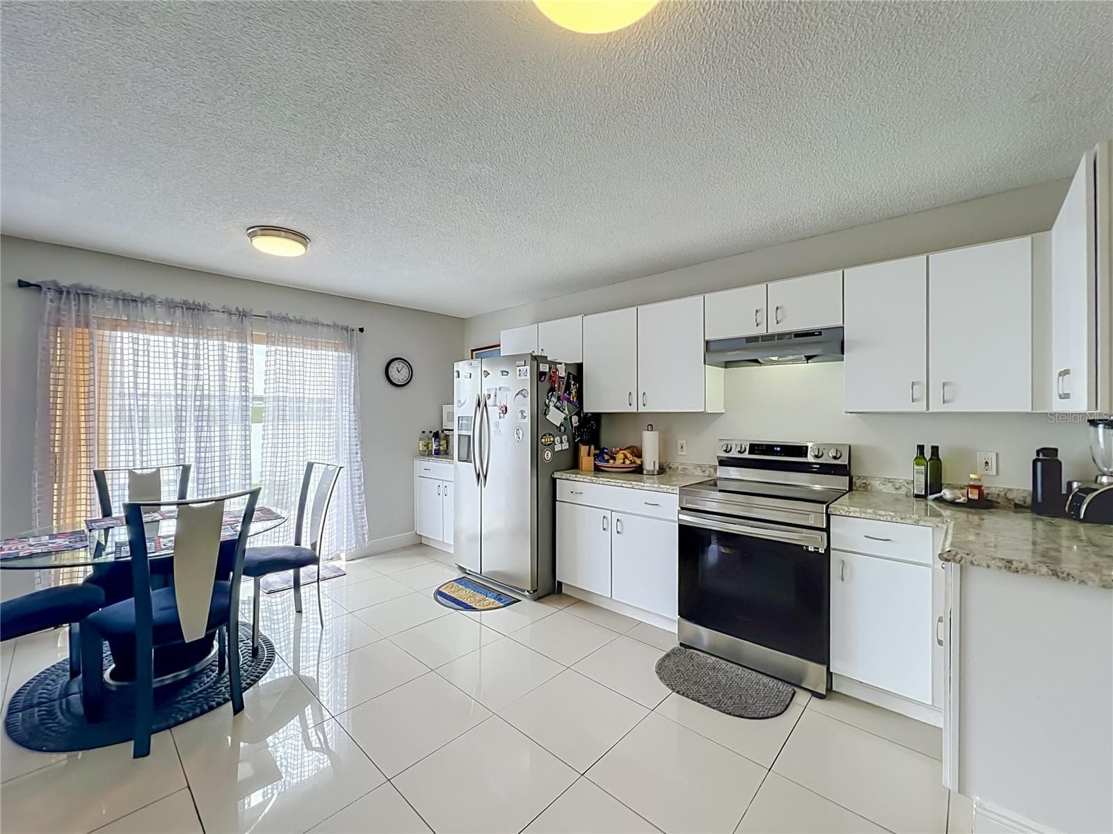 Dinette area in kitchen with sliding doors to the back yard and pond front - 12900 LOS ALAMITOS CT, ORLANDO
