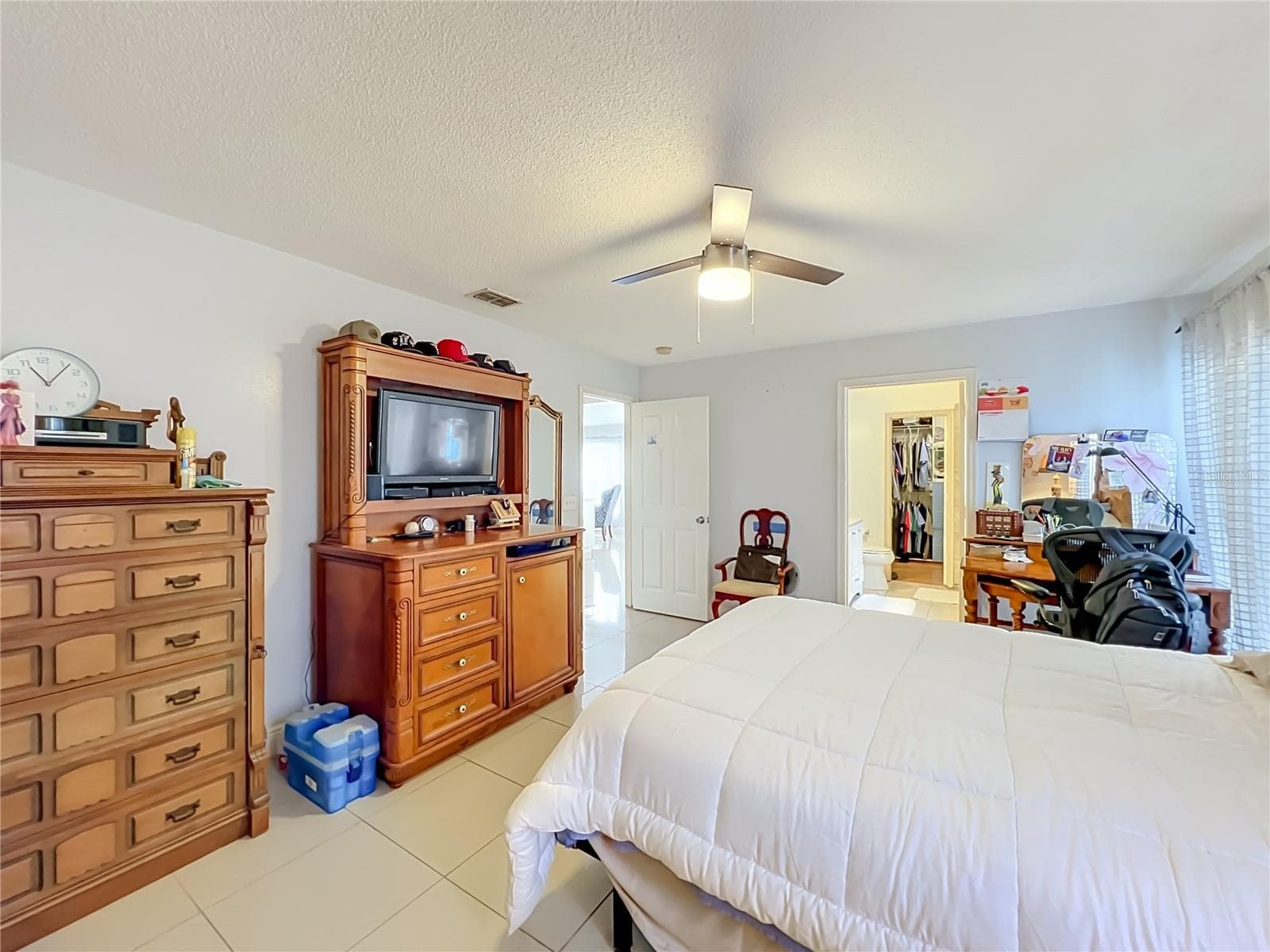 Primary bedroom on 1st floor with ceiling fan and ceramic tile floor - 12900 LOS ALAMITOS CT, ORLANDO
