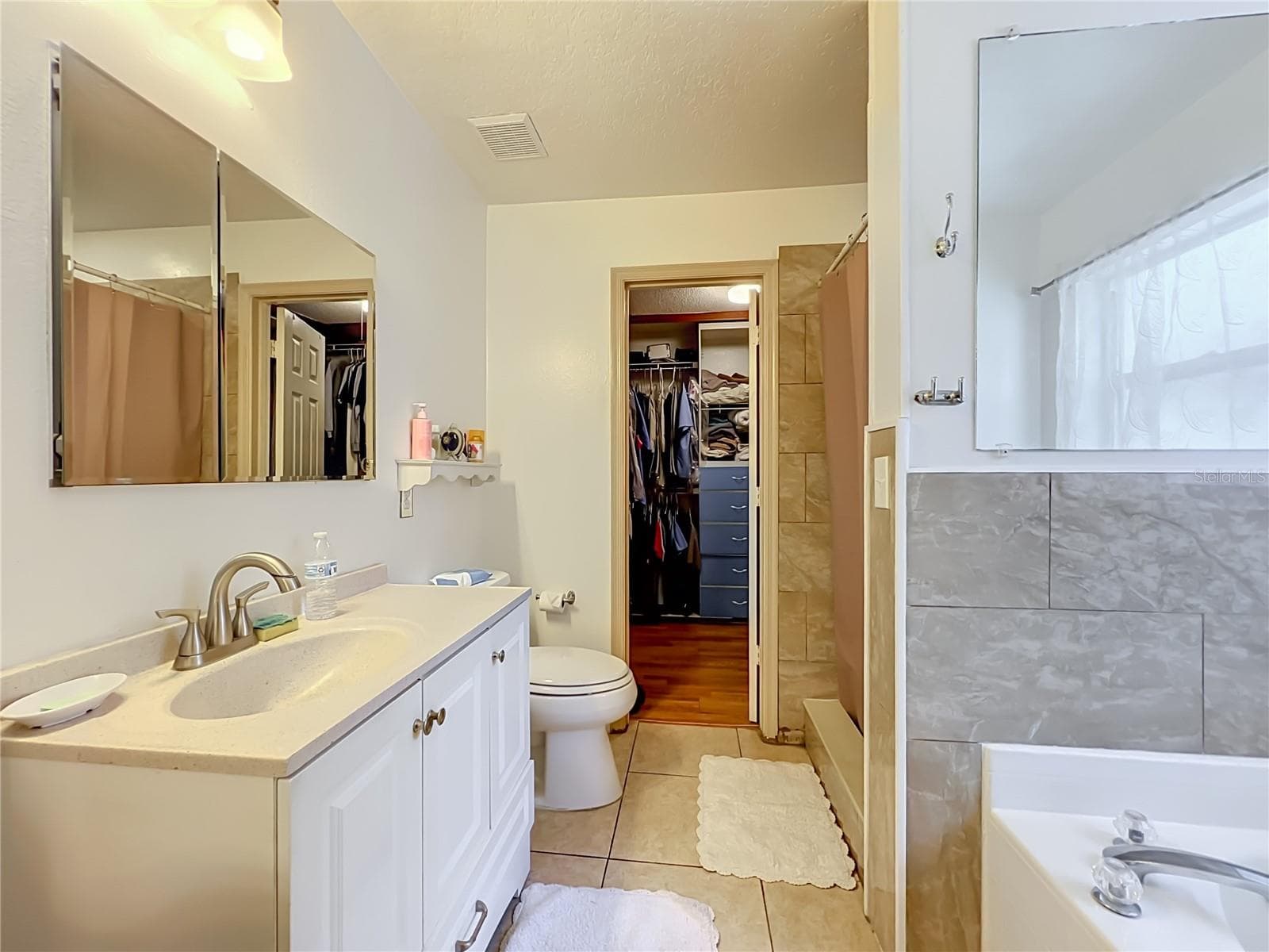 Primary bath with single sink, vanity, walk in closet, separate shower and garden tub - 12900 LOS ALAMITOS CT, ORLANDO