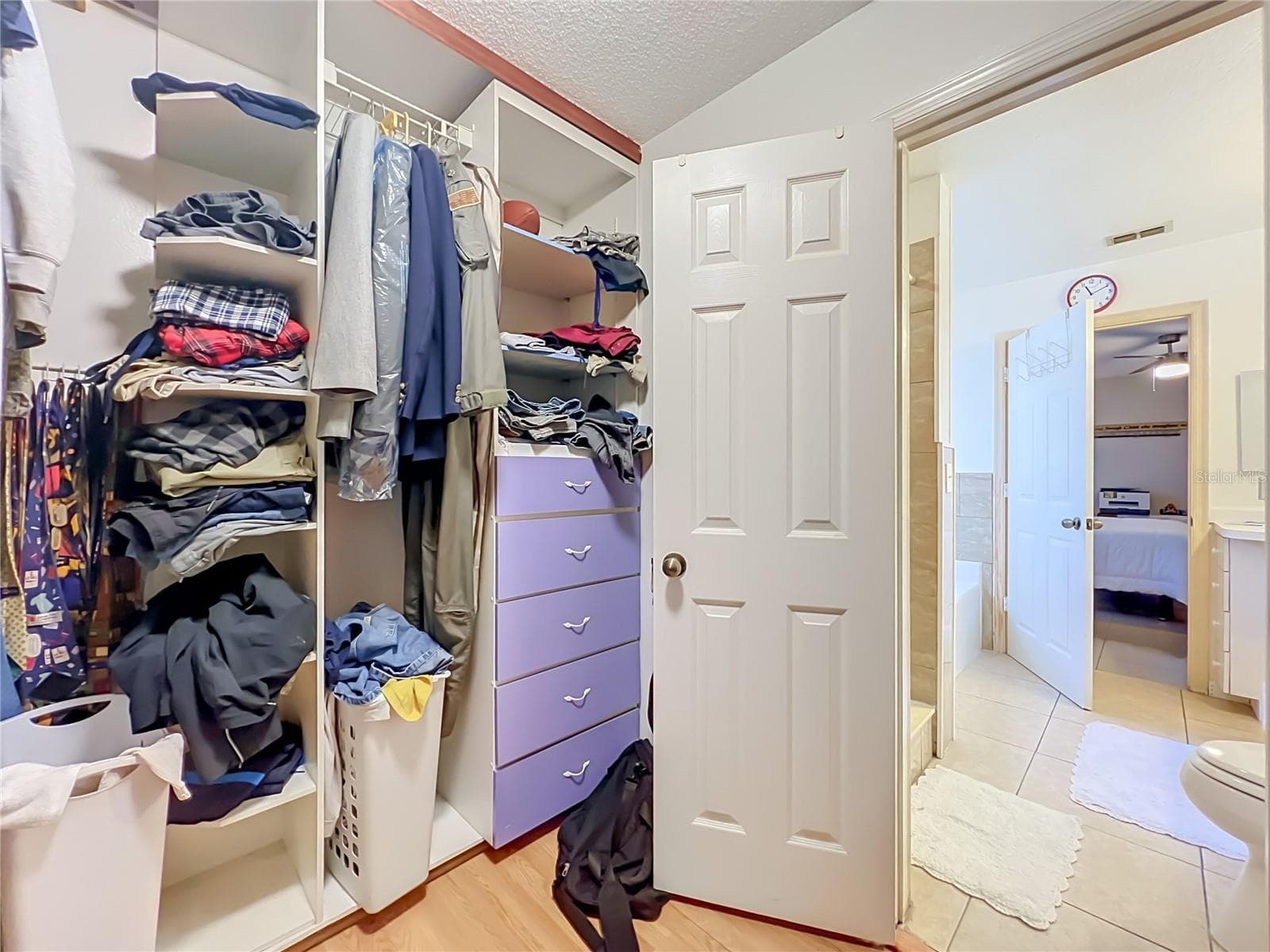 Wood floors and built in drawers and shelving in the large Primary walk in closet - 12900 LOS ALAMITOS CT, ORLANDO