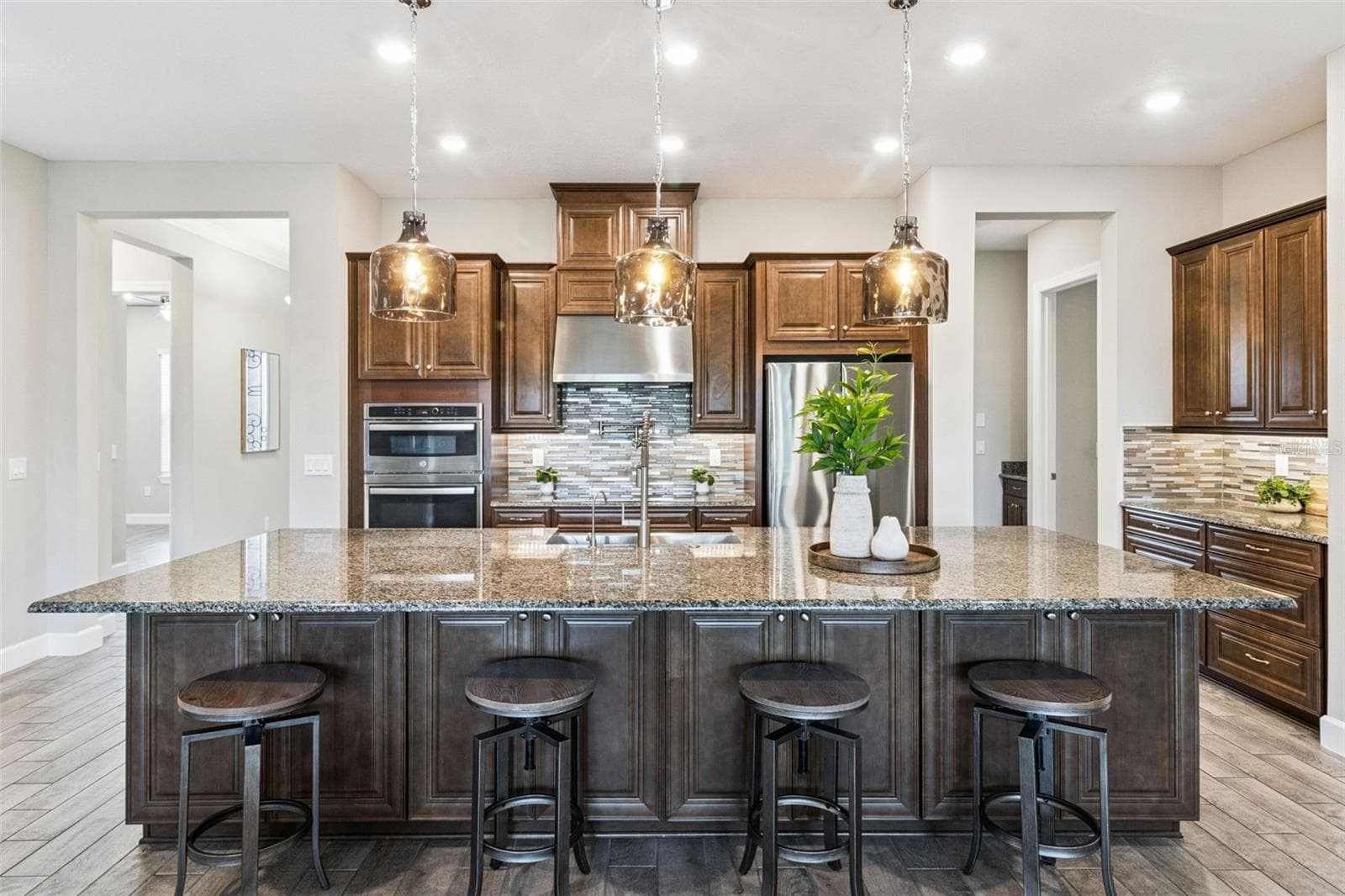 Centrally located kitchen with granite island, breakfast bar seating, solid wood cabinetry, and stainless steel appliances. - 4108 VIA TOLEDO CT, POINCIANA