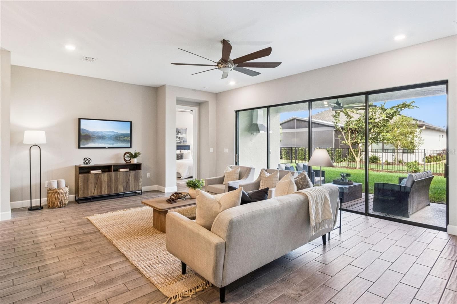 Living room with sliding glass doors and relaxing backyard views in Solivita, Poinciana. - 4108 VIA TOLEDO CT, POINCIANA