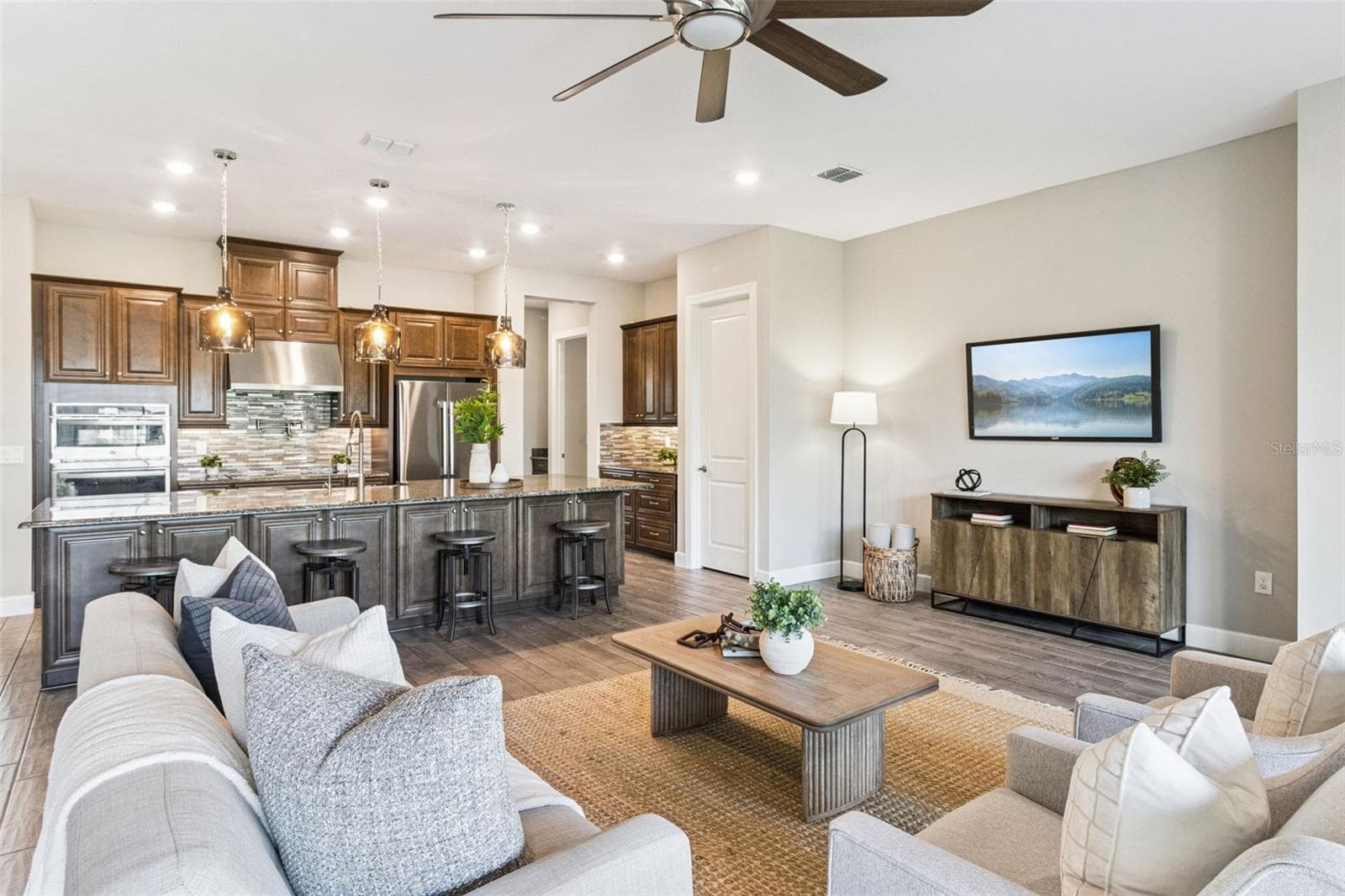Open great room layout connecting the kitchen, living, and dining spaces. - 4108 VIA TOLEDO CT, POINCIANA
