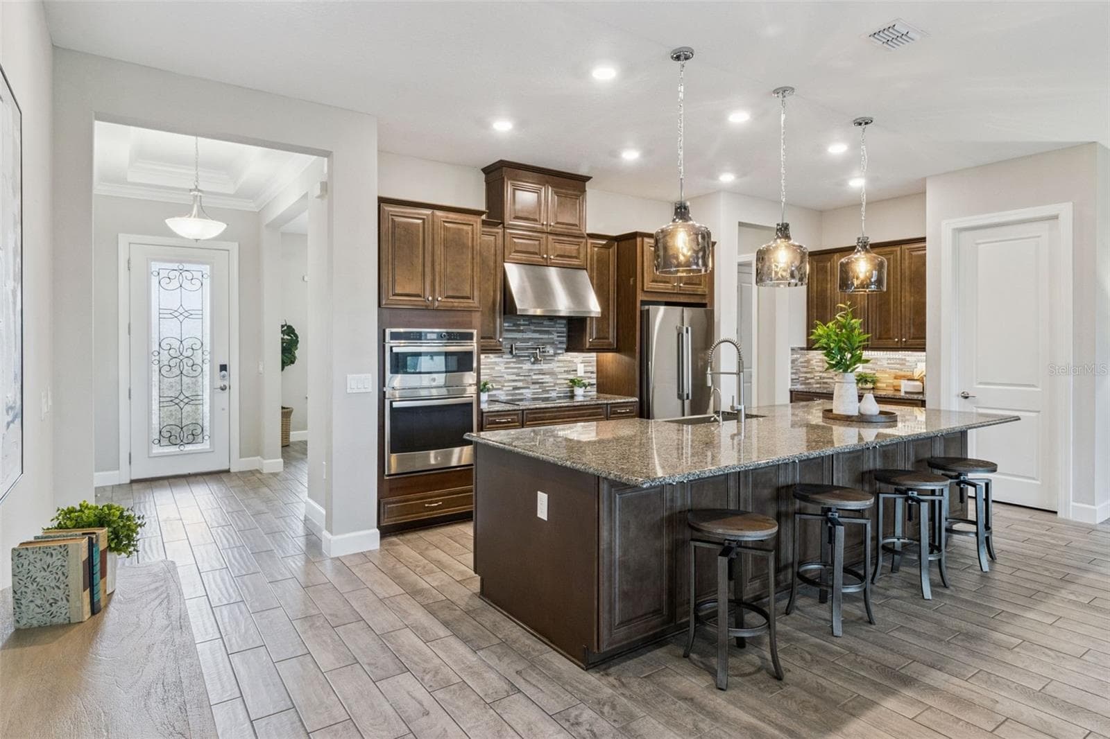 Kitchen with island seating, double wall ovens, and convenient access to the main living areas. - 4108 VIA TOLEDO CT, POINCIANA